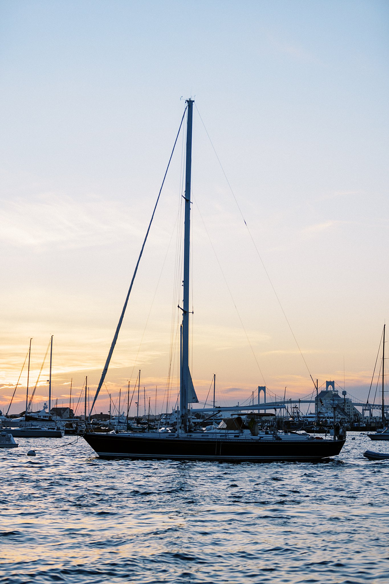 sailboat sits in bay by Lynne Reznick Photography