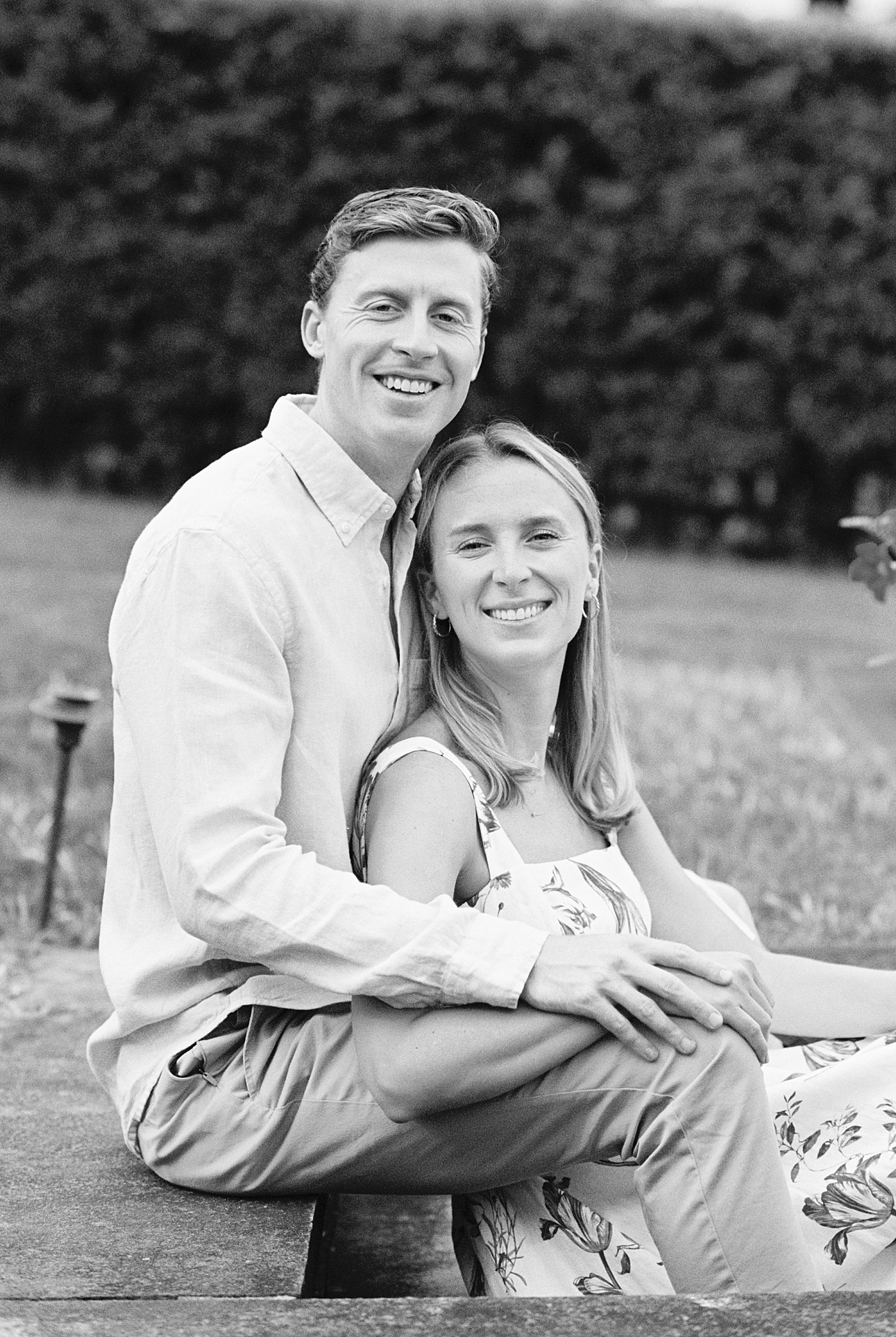 man and woman snuggle in grass watching boats in Cotuit Bay