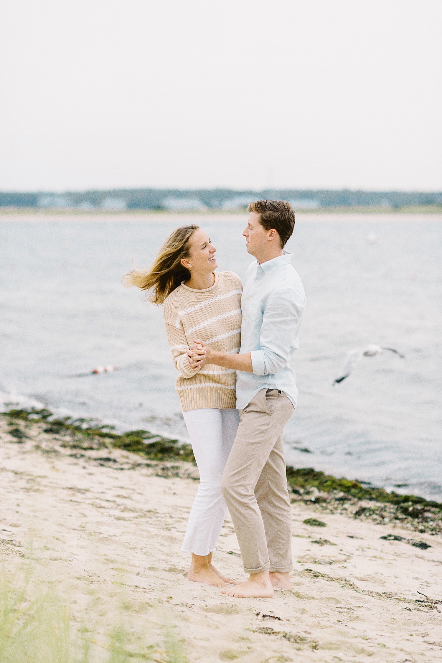 man leads wife-to-be in a dance on the sand by Lynne Reznick Photography