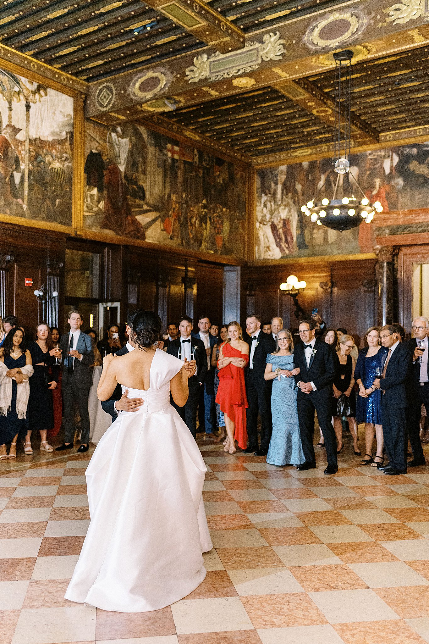 guests look on as couple shares first dance at reception