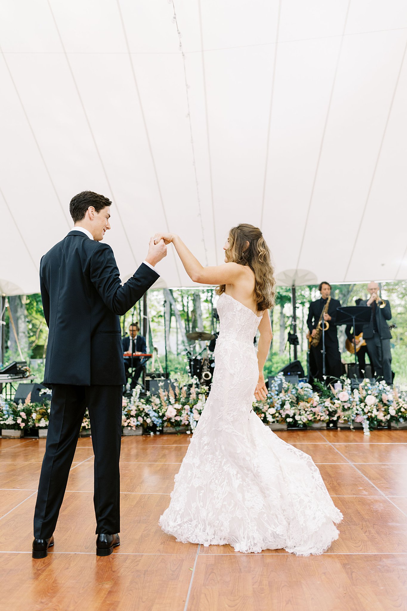 groom holds up bride's hand as she spins by Boston wedding photographer