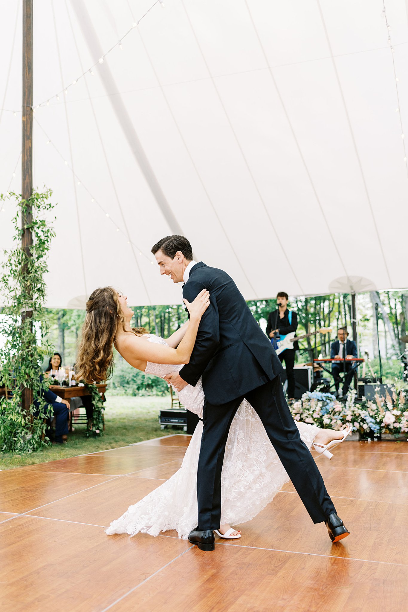 groom dips bride as she laughs by Lynne Reznick Photography