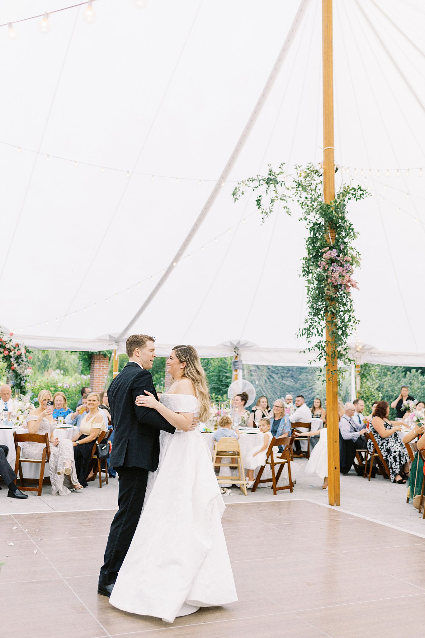 bride smiles at groom on dancefloor as guests watch by Boston wedding photographer