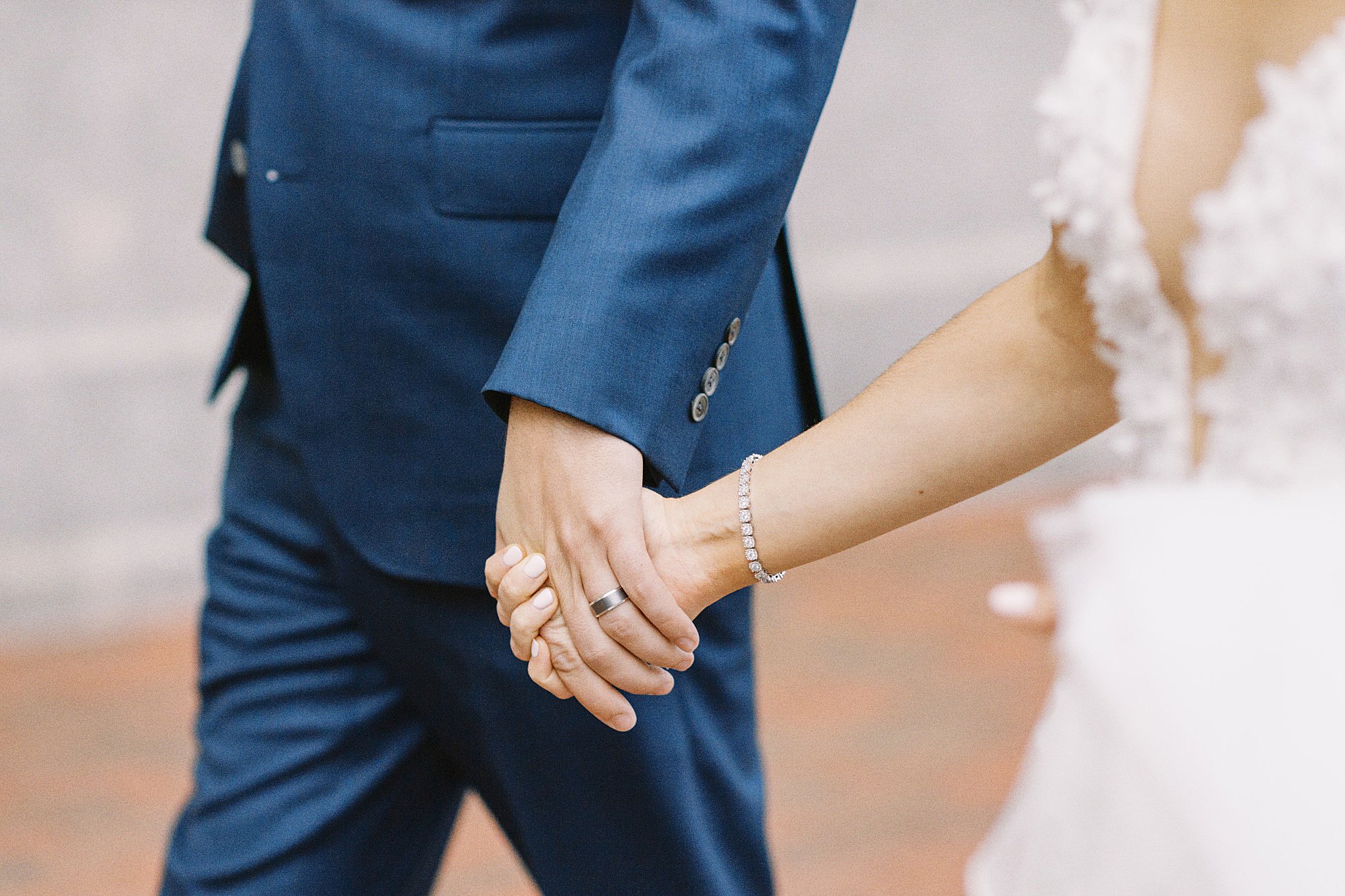 bride and groom hold hands by Boston wedding photographer