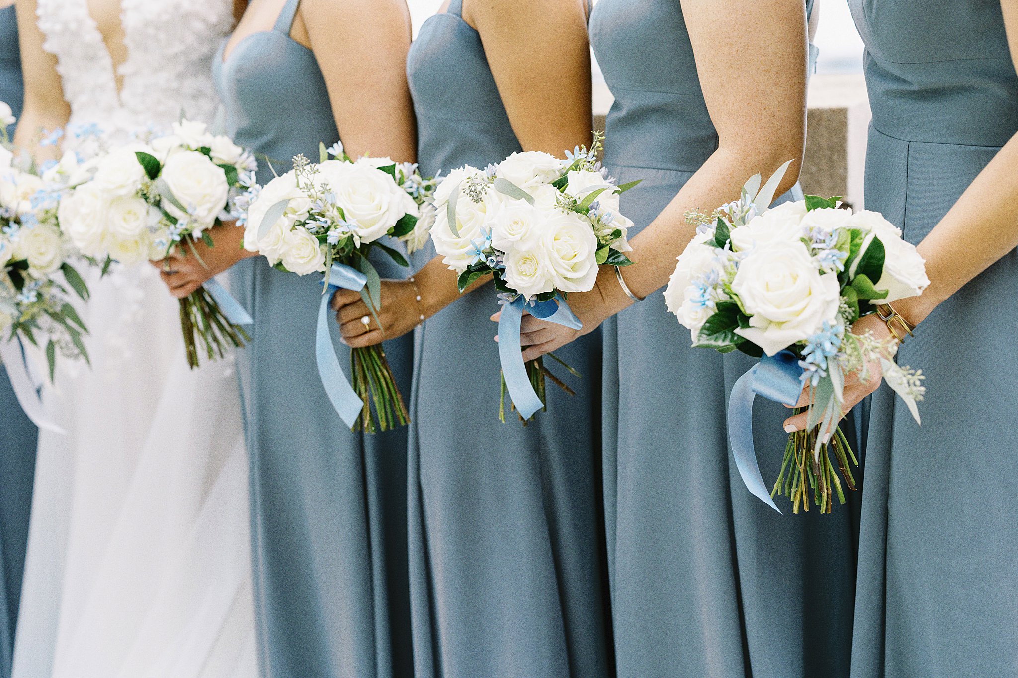 bridesmaids hold white bouquets at Boston Harbor Hotel