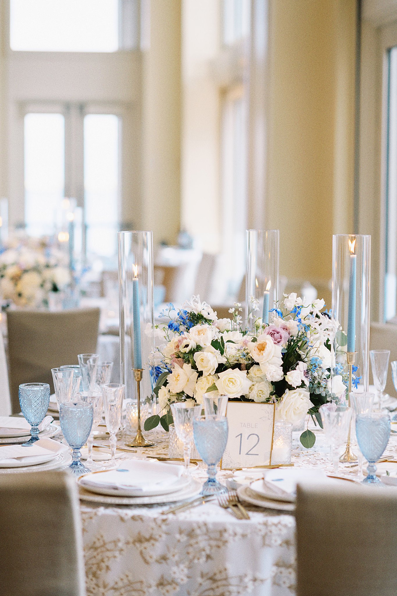 low florals and tall hurricane vases decorate reception tables by Lynne Reznick Photography 