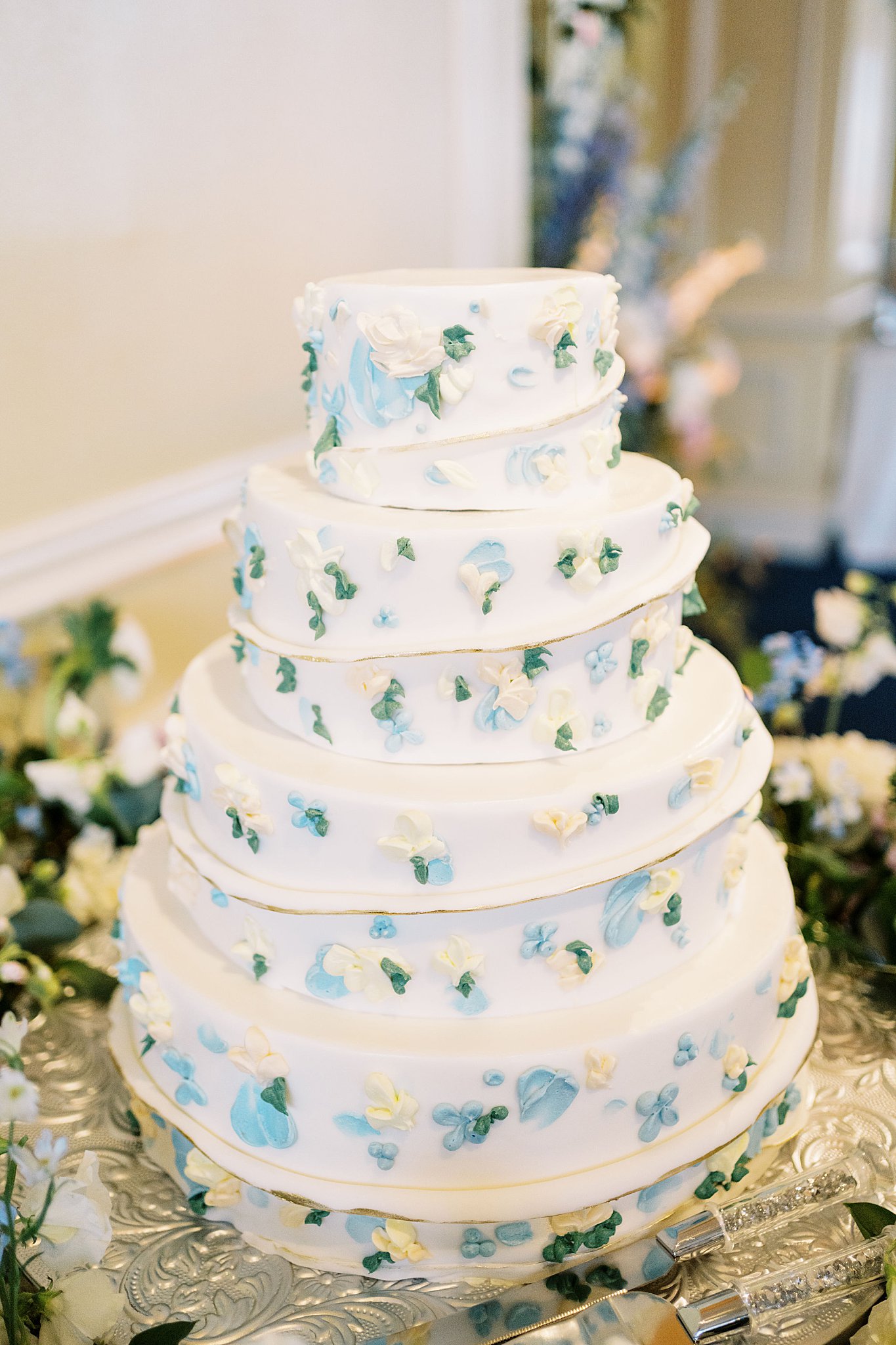 wedding cake with flowers decorating it by Lynne Reznick Photography 