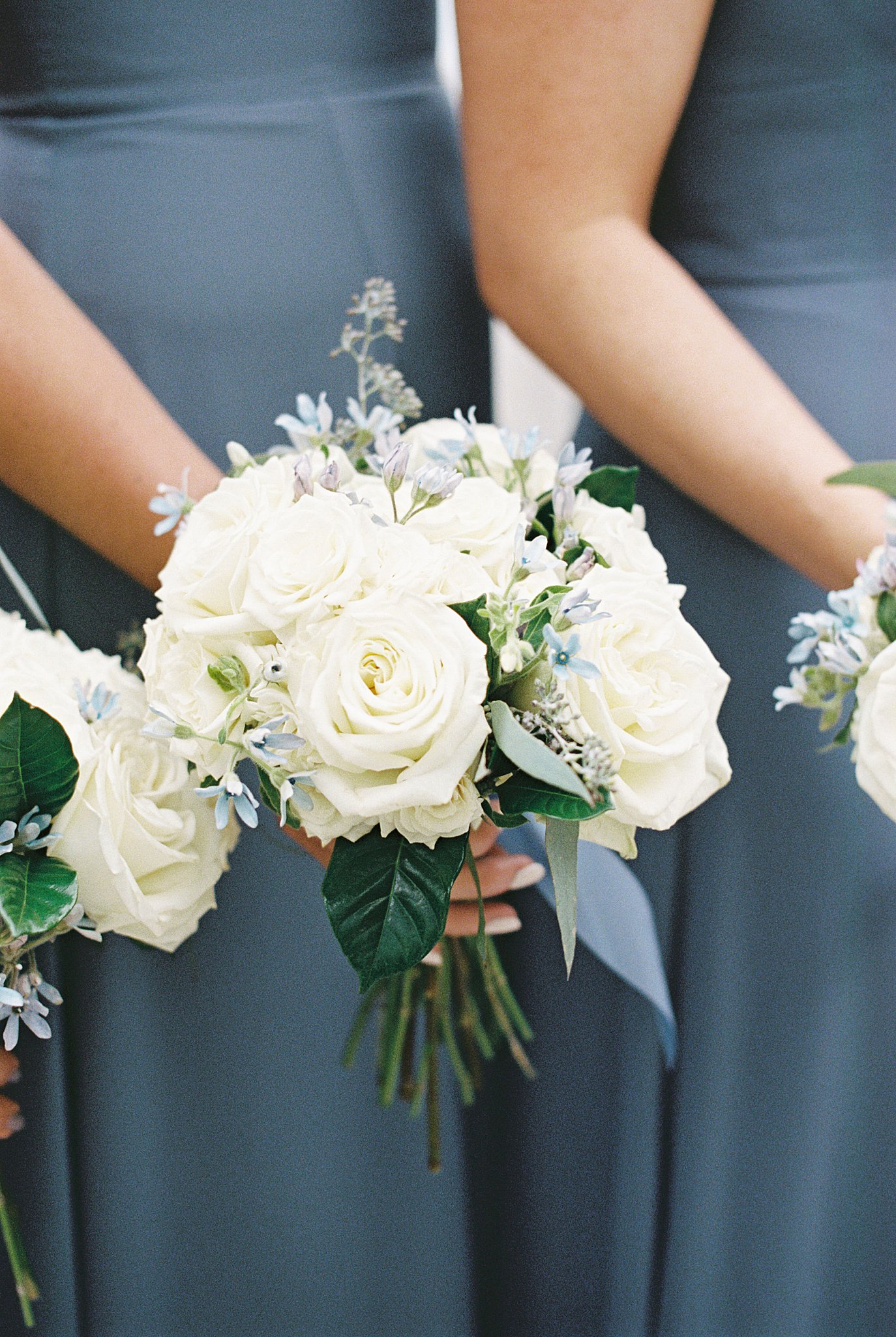 bridesmaids hold small bouquets of white flowers by Boston wedding photographer