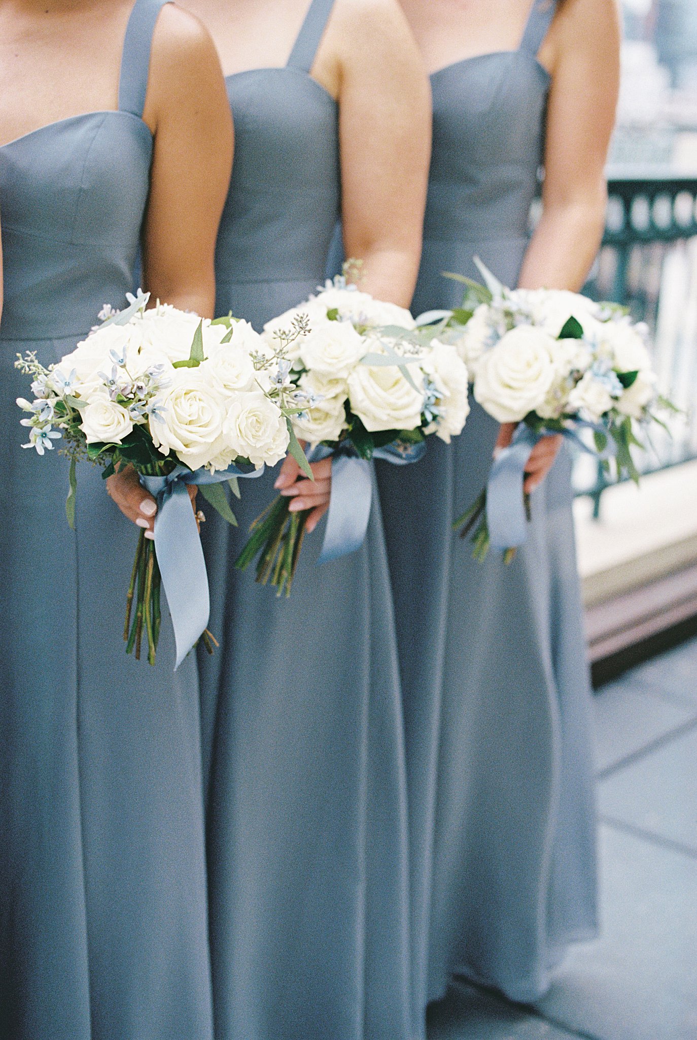 bridesmaids hold out bouquets at Boston Harbor Hotel