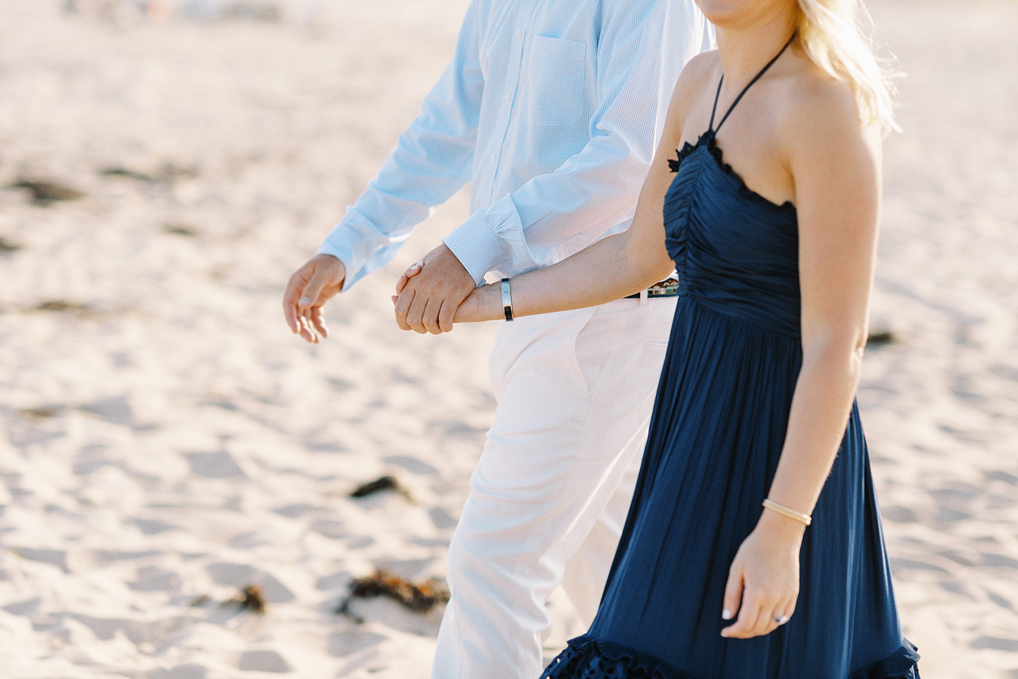 couple walks hand in hand at Watch Hill engagement session