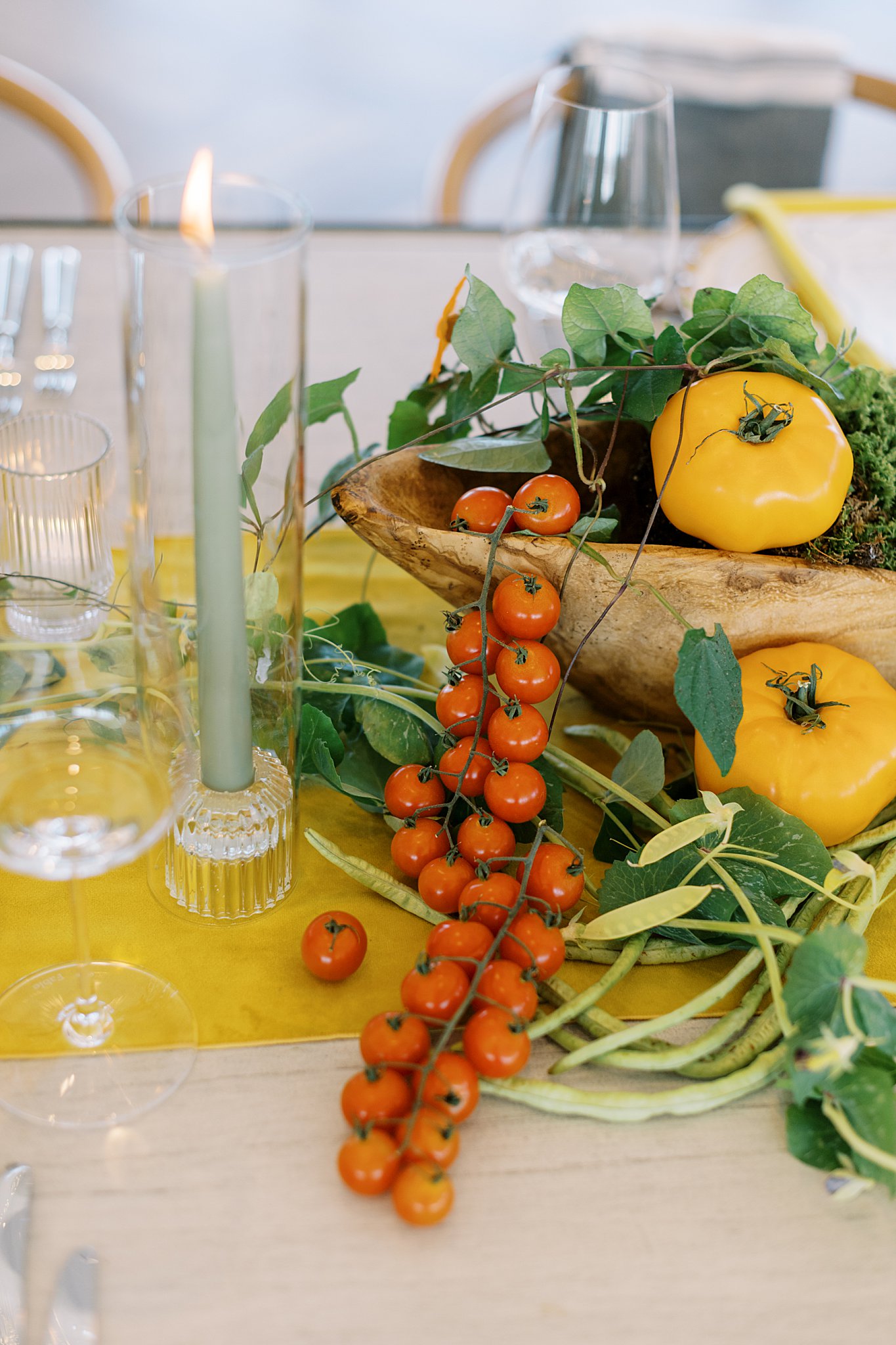 woden vessel overflows with tomatoes and greenery on table by Cape Cod wedding photographer