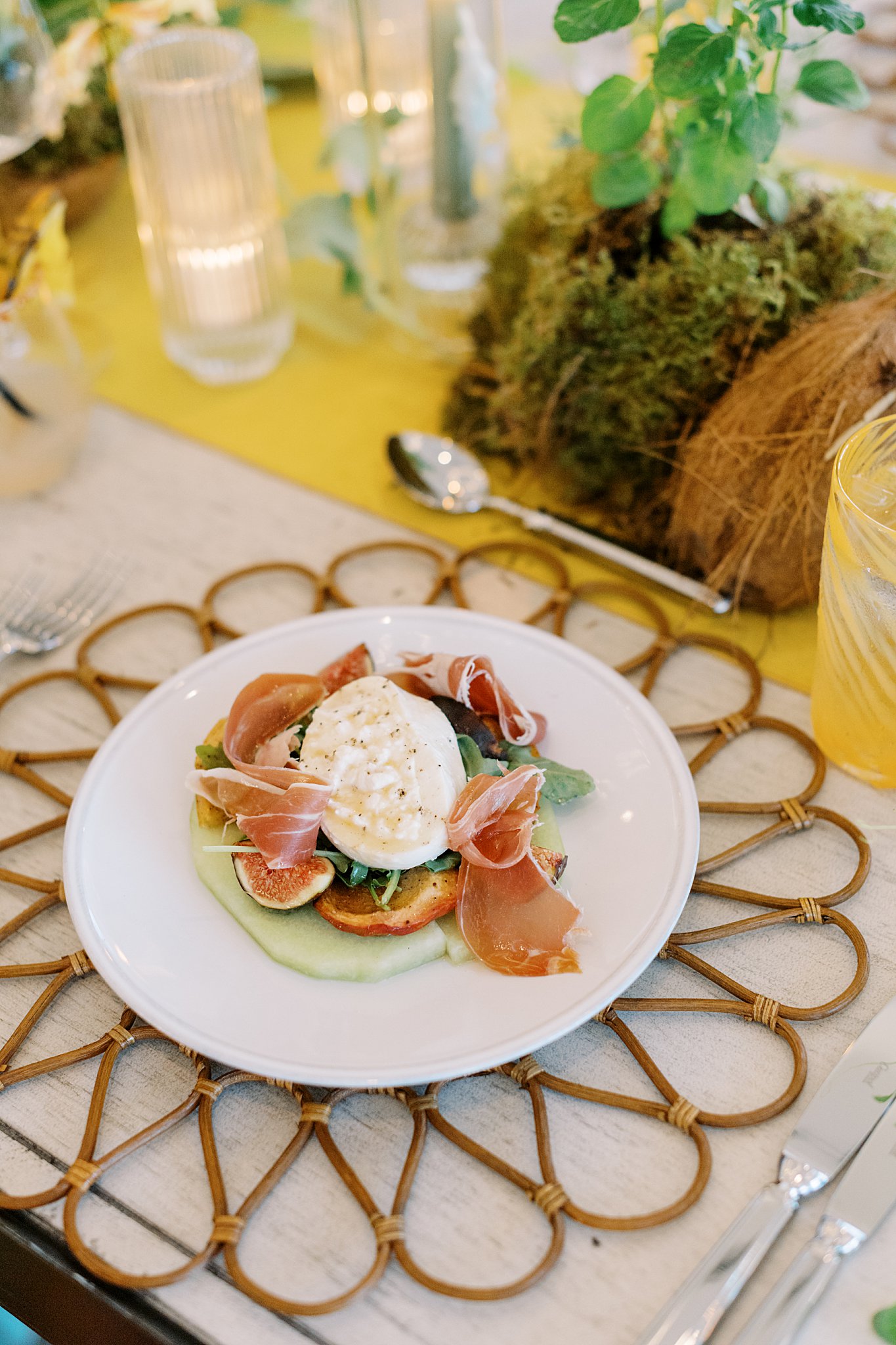 appetizer plate with burrata placed on wicker charger by Cape Cod wedding photographer