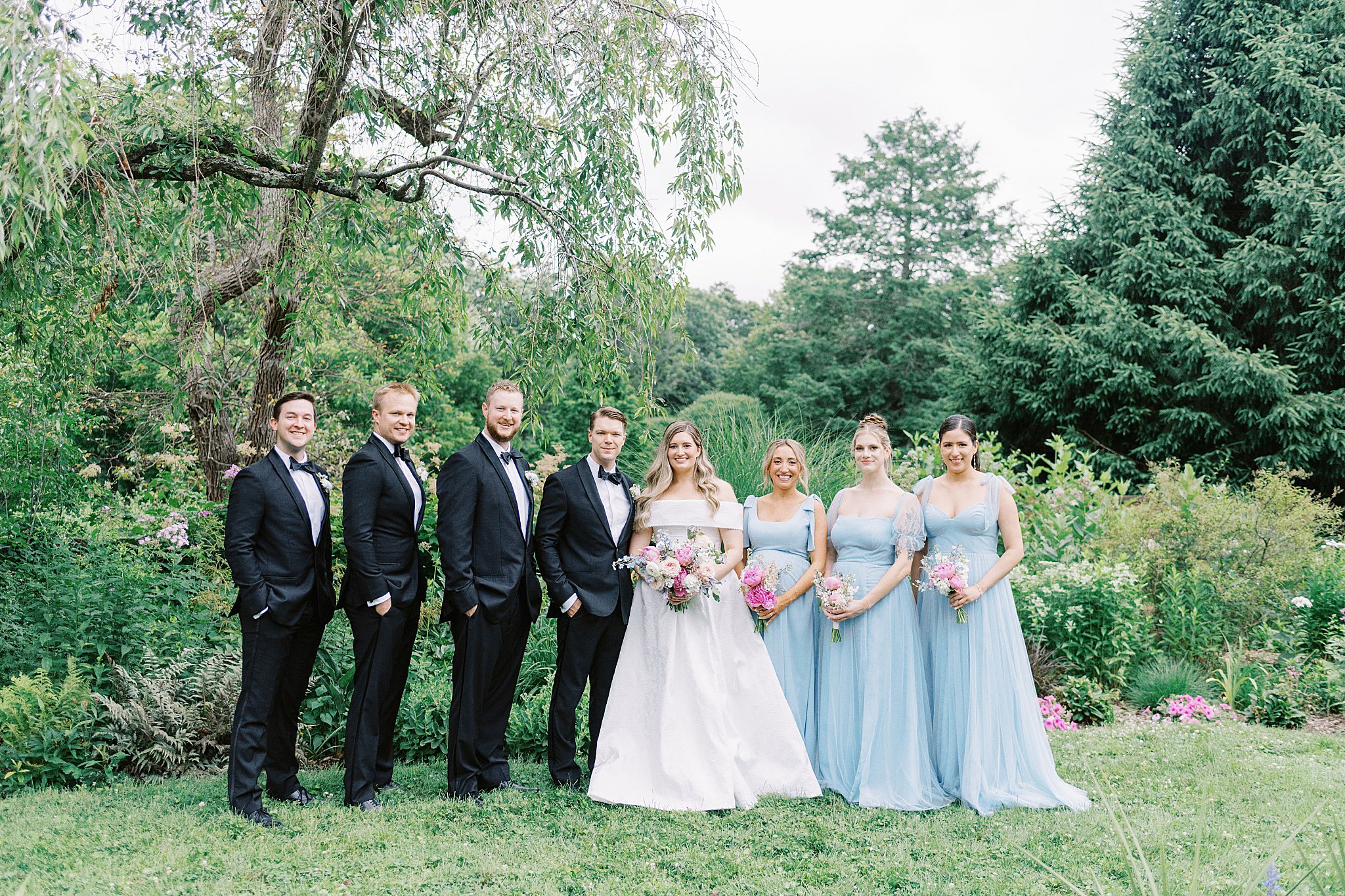 wedding party gathers around bride and groom by Lynne Reznick Photography