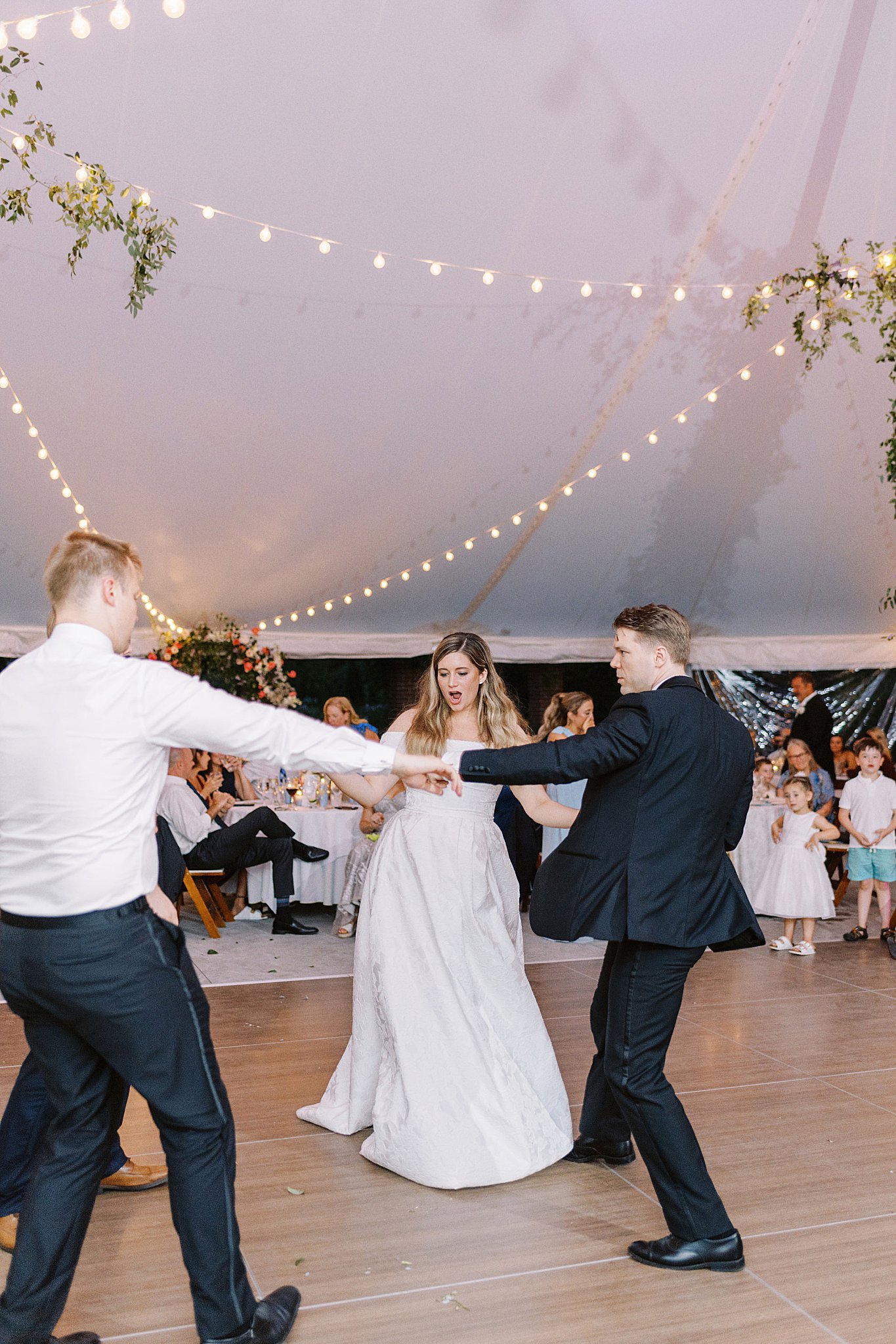 newlyweds dance with guests at reception by Lynne Reznick Photography