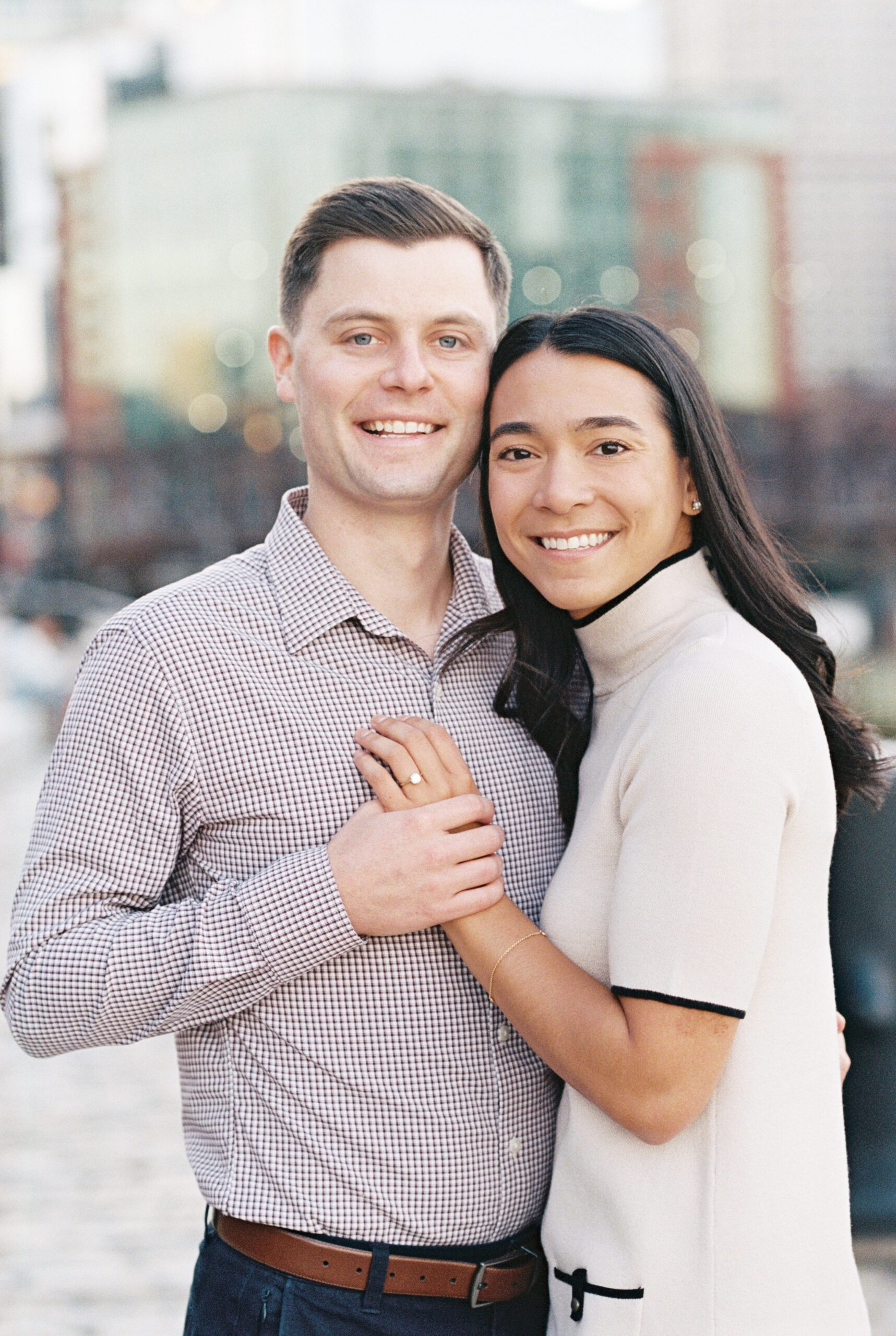 Fan Pier Park engagement portrait of bride and groom snuggled together and smiling for the camera
 