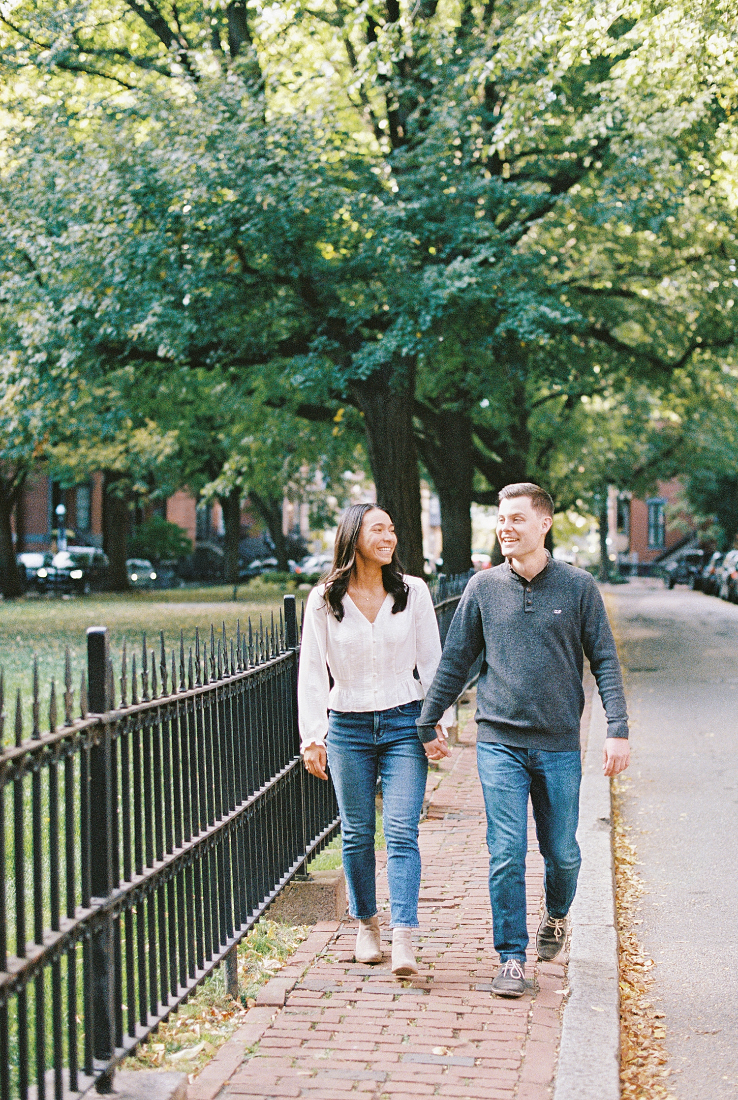 Couple walks down sidewalk before Fan Pier Park Engagement Session