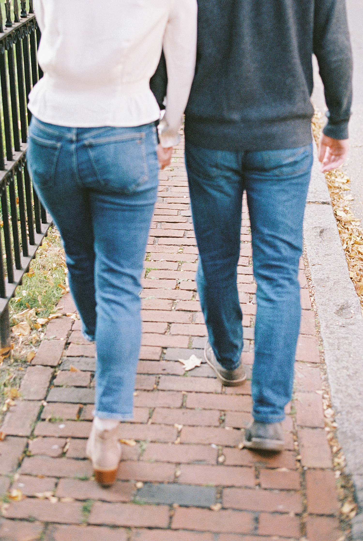 couple walk down the street hand in hand by Boston Wedding Photographer