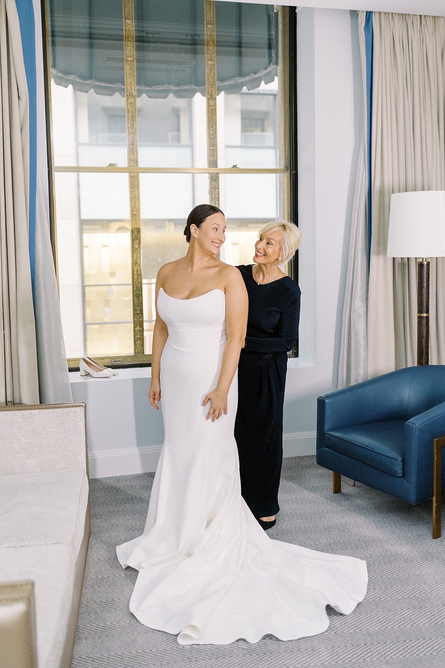 mother zips up her daughter's white gown in Langham Hotel