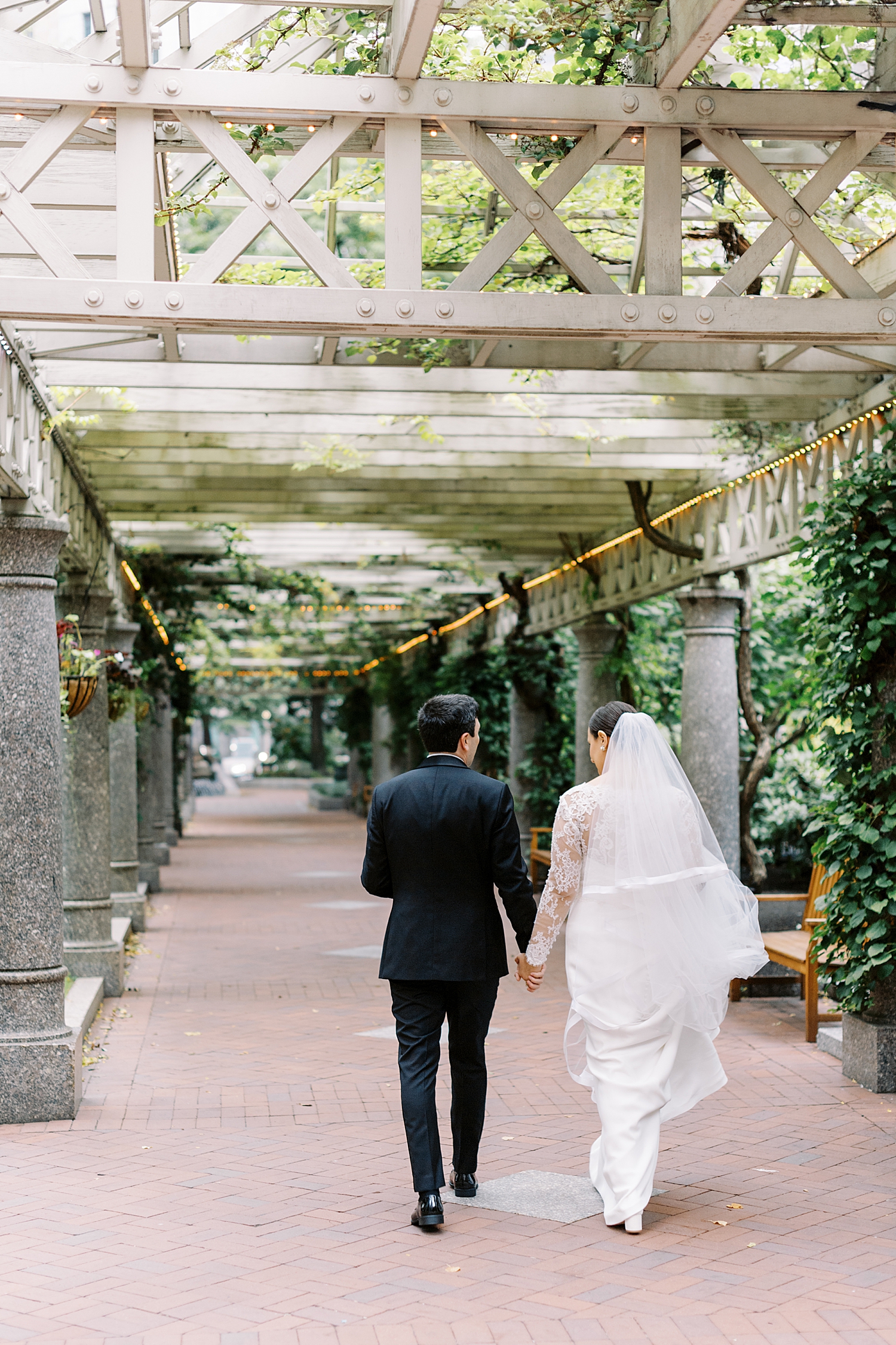 newlyweds walk down garden path by Boston Wedding Photographer 