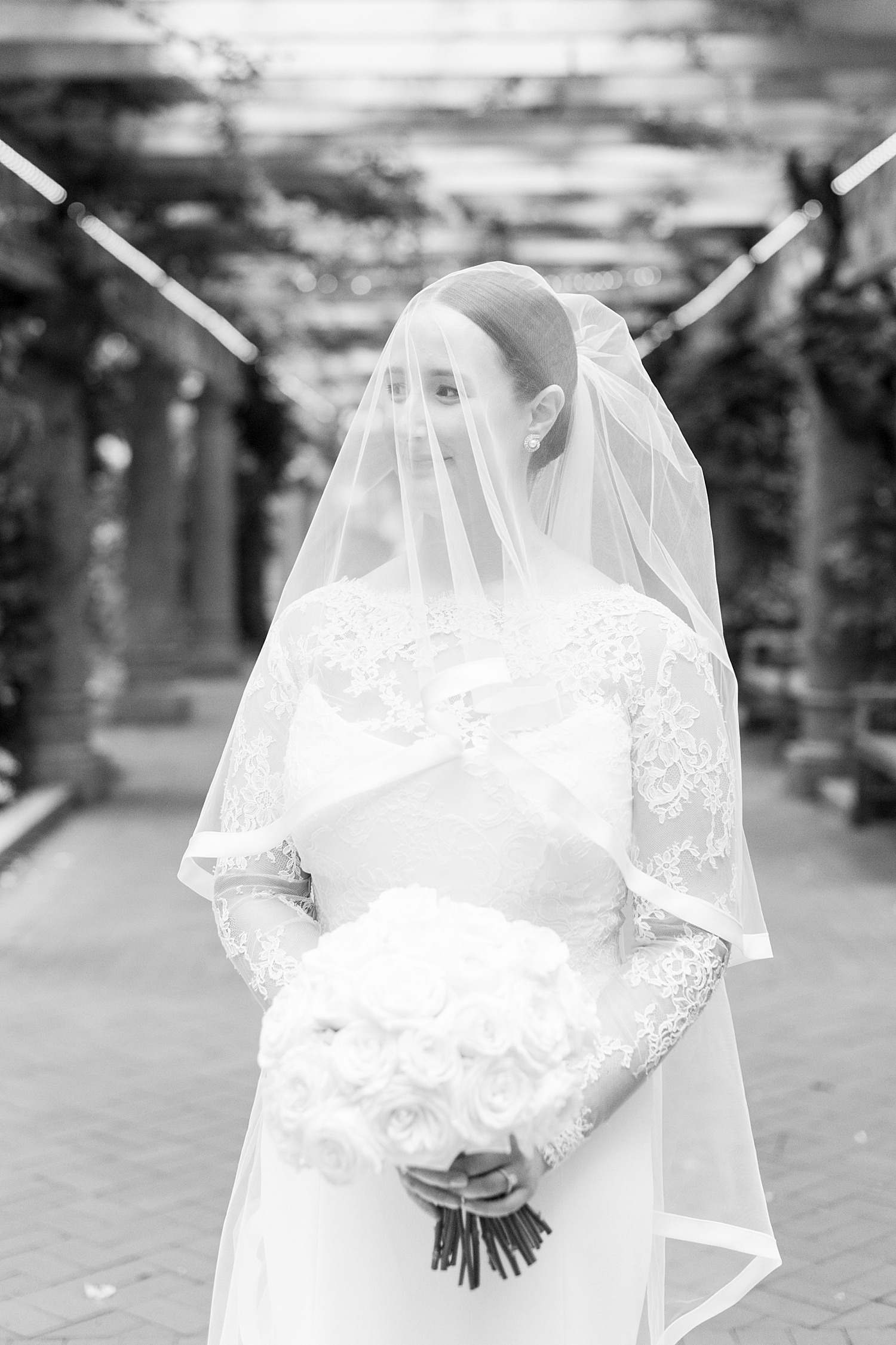 woman covered in veil holds flowers at Langham Hotel