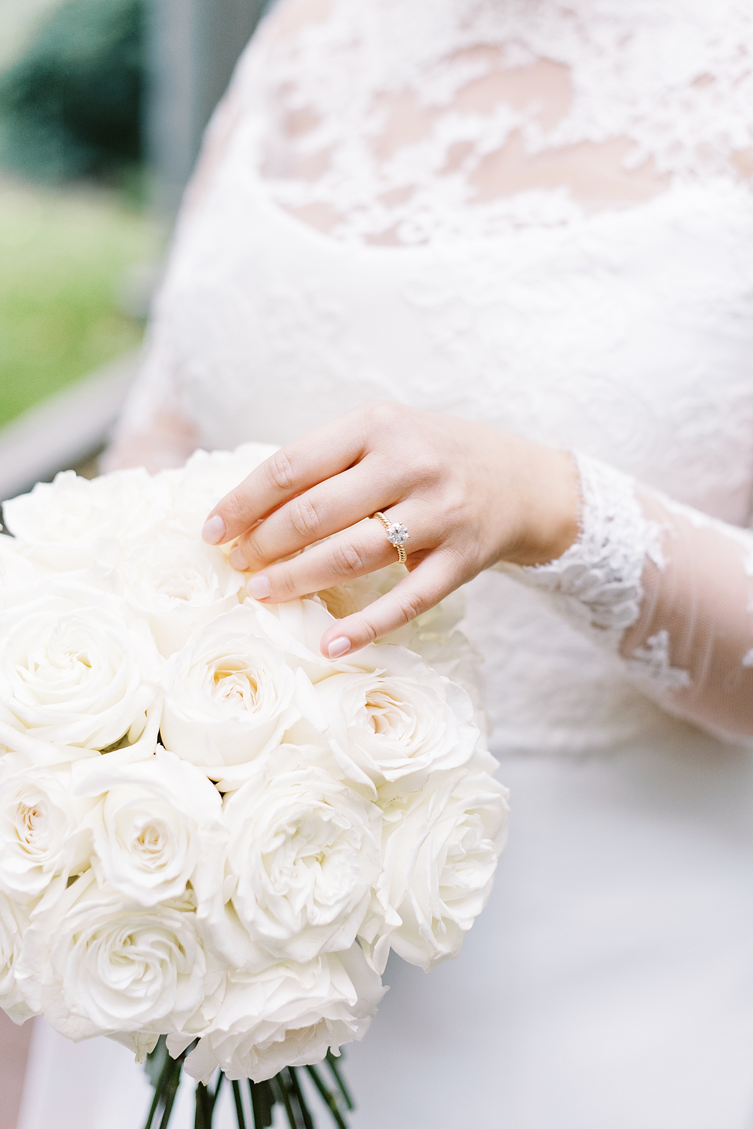 woman with diamond ring on her finger holds flowers by Boston Wedding Photographer 