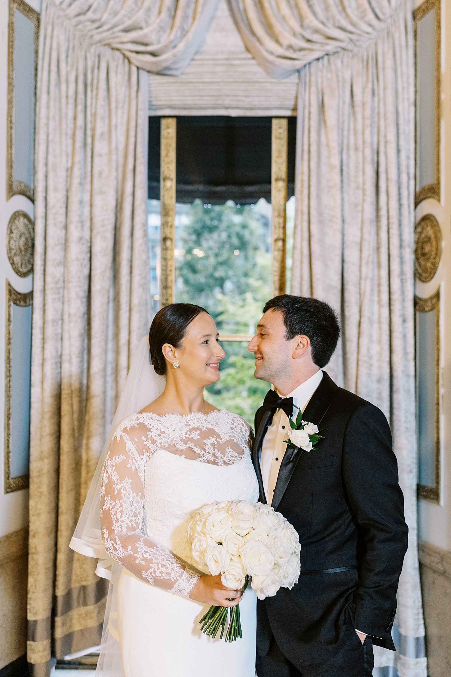 couple gazes at each other in front of large window by Lynne Reznick Photography