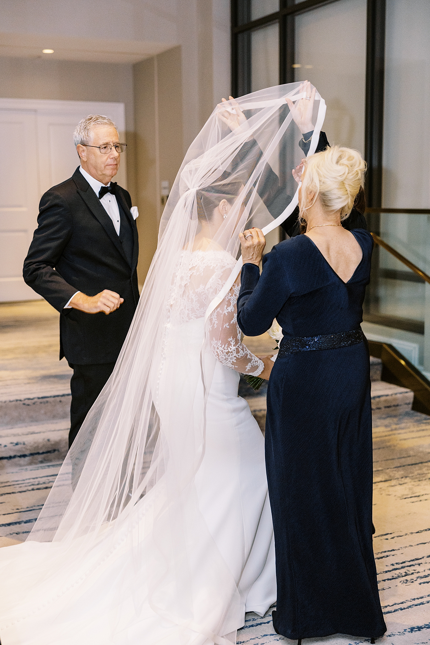 Bride's mother lifts veil over her face by Lynne Reznick Photography