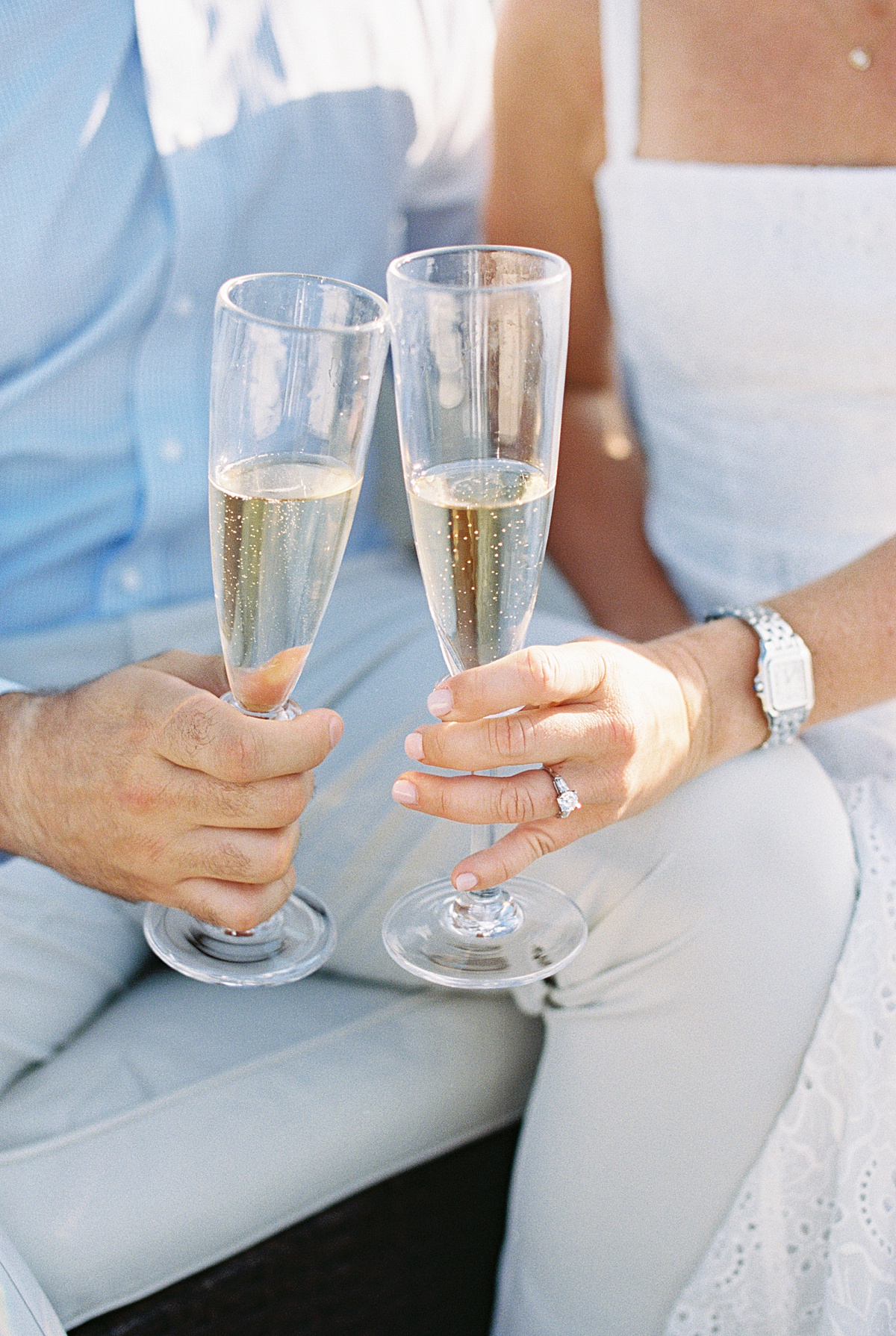 Couple hold glasses of champagne together during their Charlestown Engagement Session 