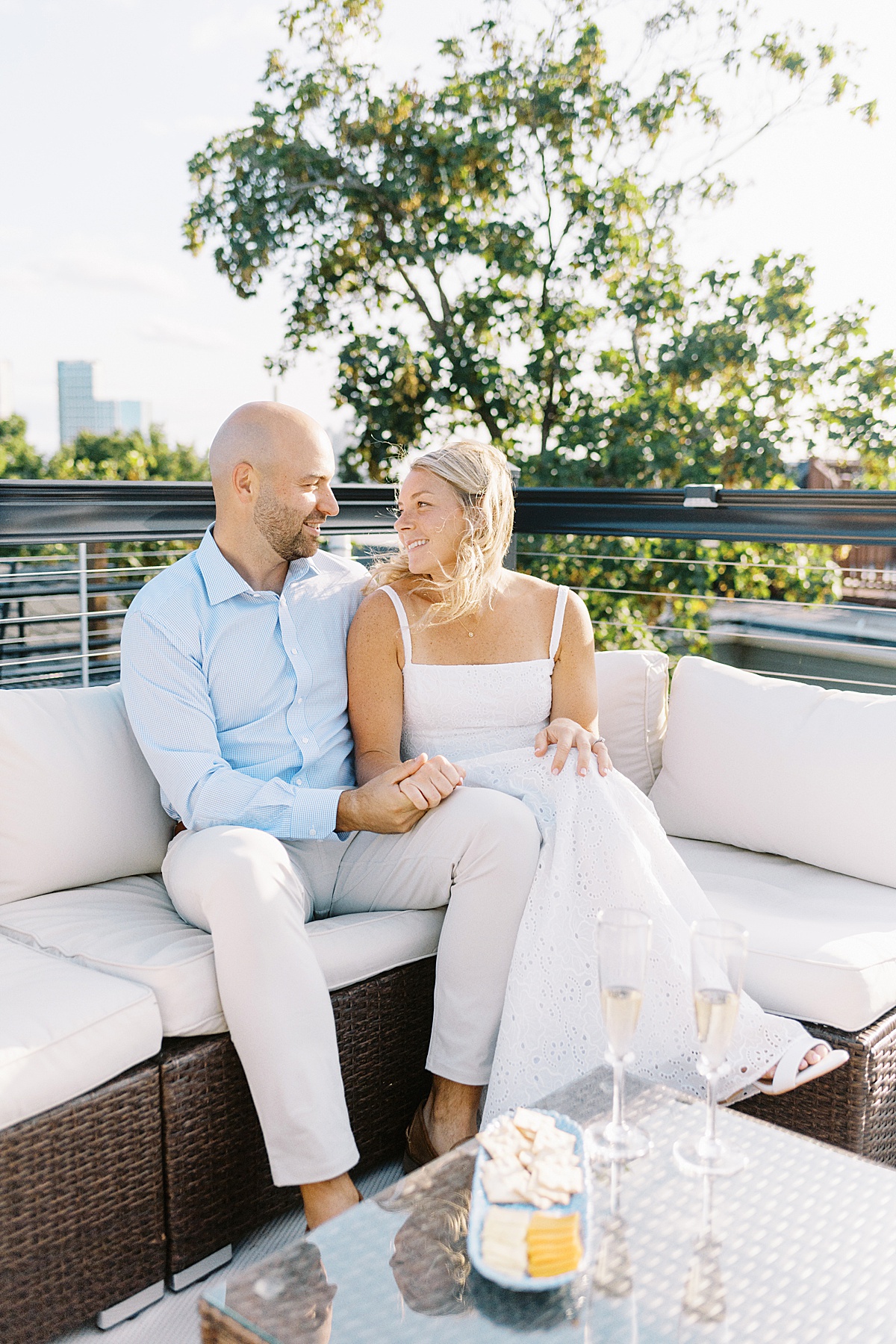 Couple sit together smiling at each other during their Charlestown Engagement Session 