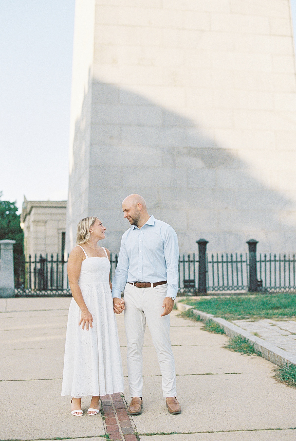 Couple hold hands and walk together during their Charlestown Engagement Session 