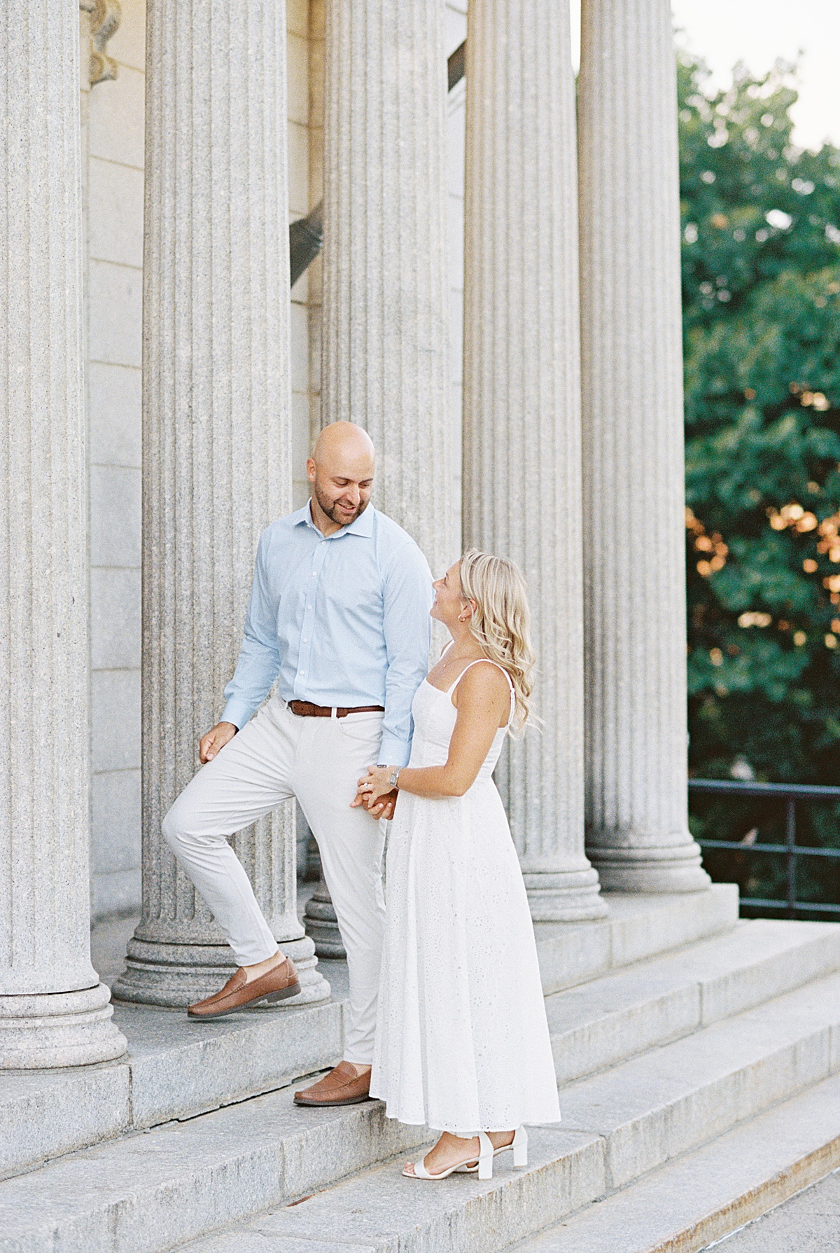 Couple hold each other's hands and walk up the steps for Boston Wedding Photographer