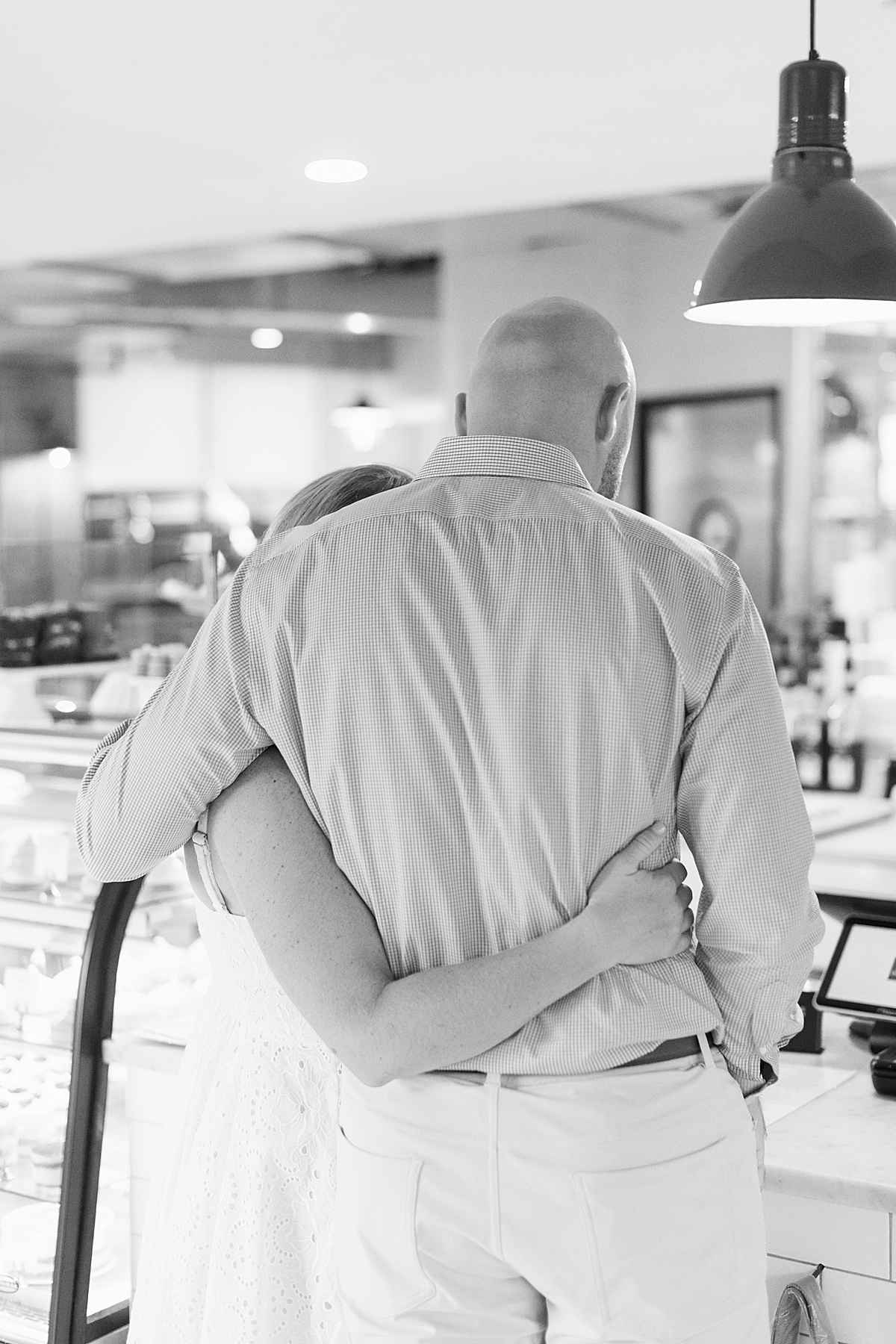 Couple hold each other in a coffee shop for Boston Wedding Photographer