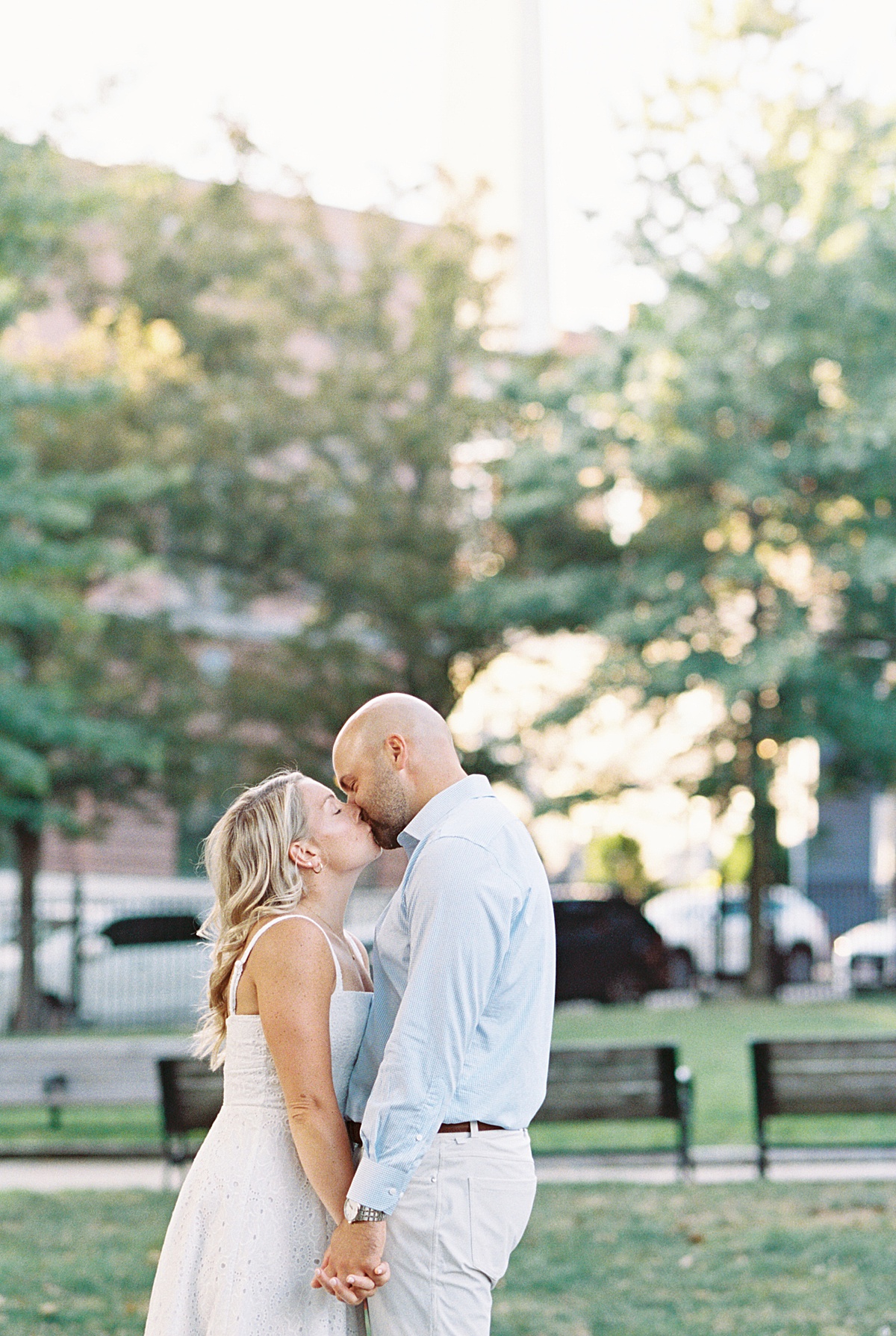 Man and woman share a kiss in a park for Lynne Reznick Photography