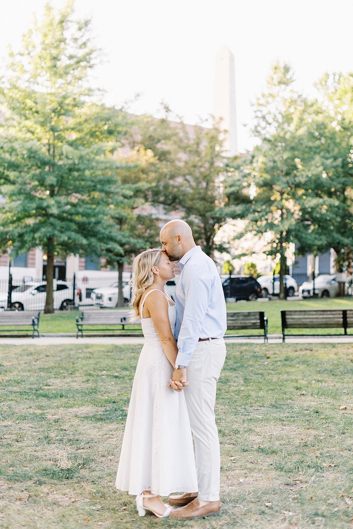 Man kisses woman on her forehead in a park during their Charlestown Engagement Session 