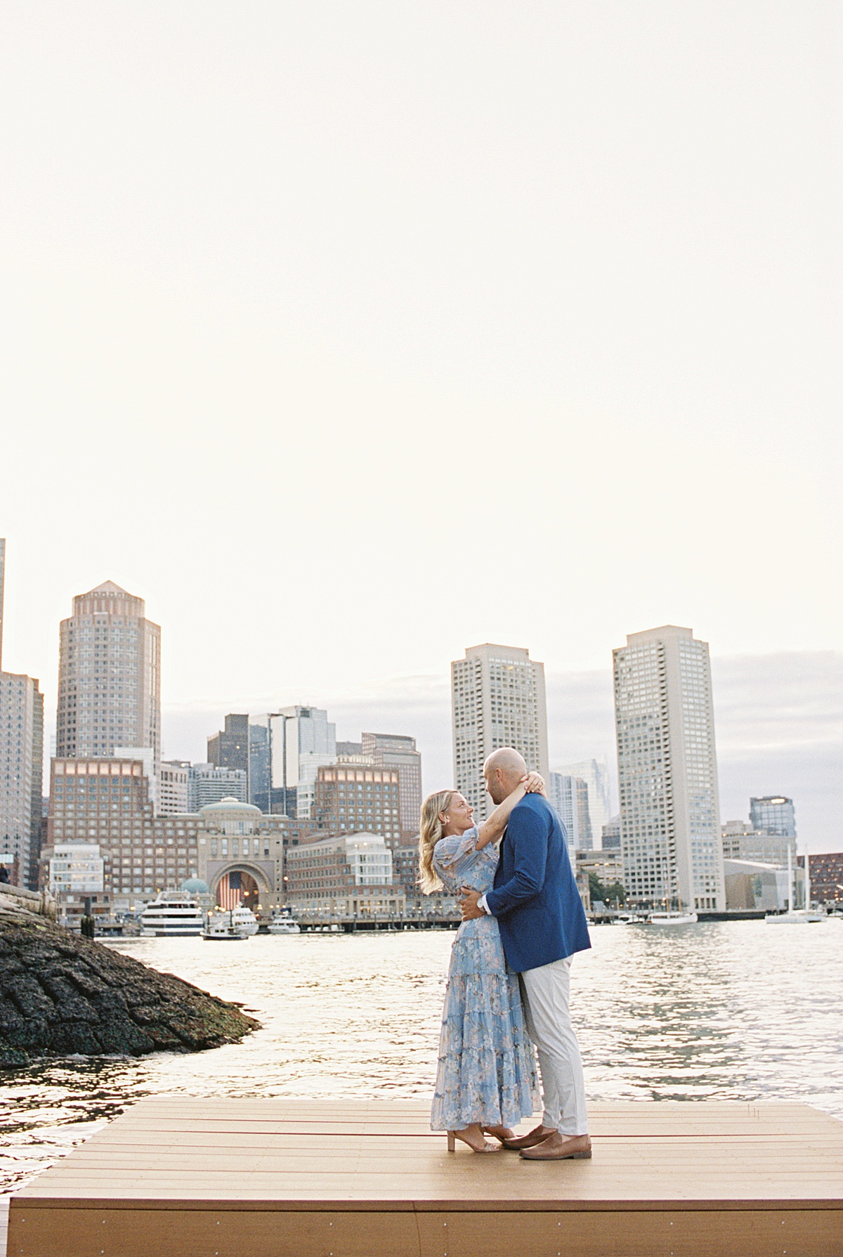 Engaged couple hold each other close on a pier for Lynne Reznick Photography