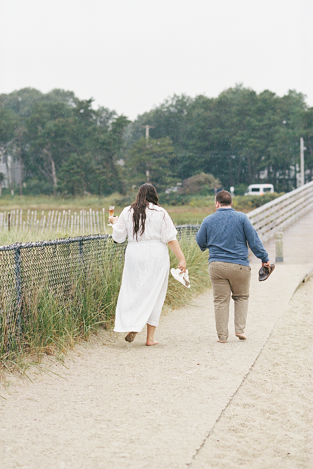 Happy couple embraces the rain and walk together on Footbridge Beach 