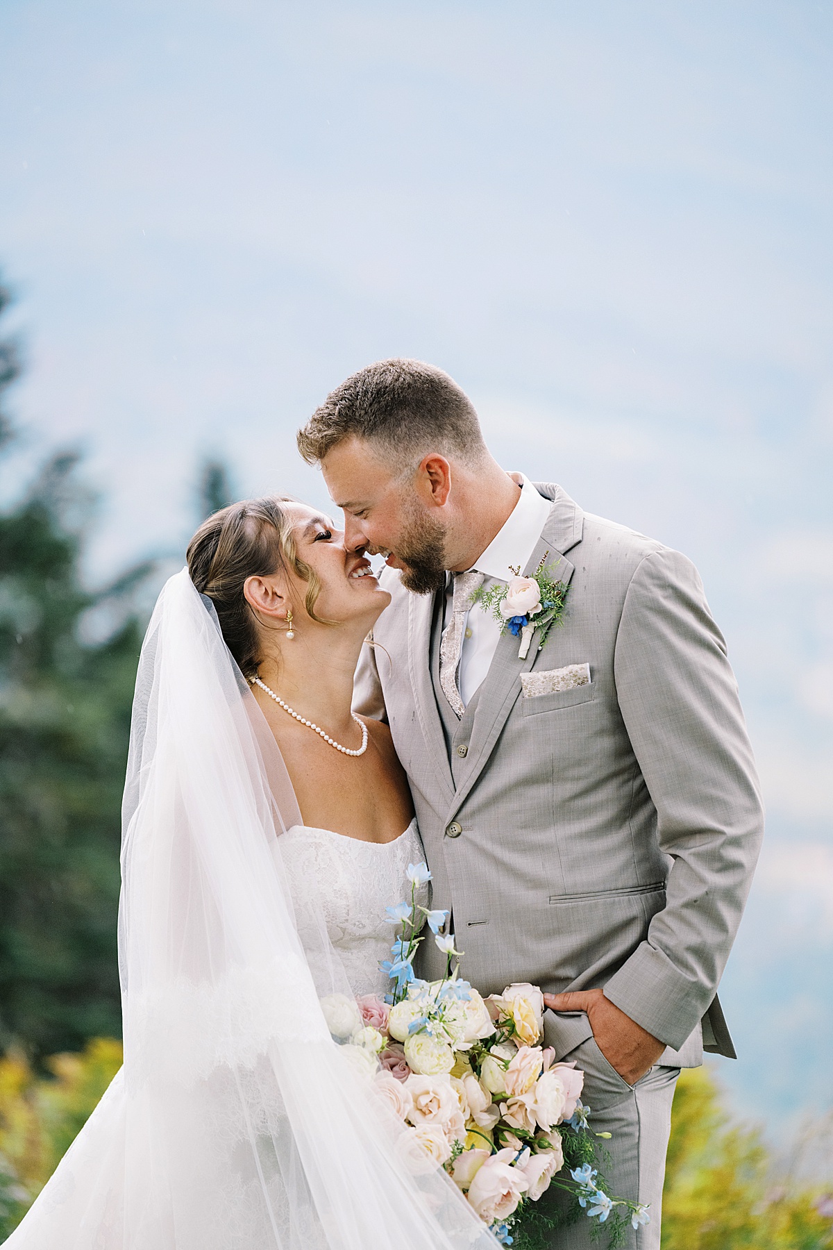 Husband and wife cuddle in close together at The Lodge at Spruce Peak