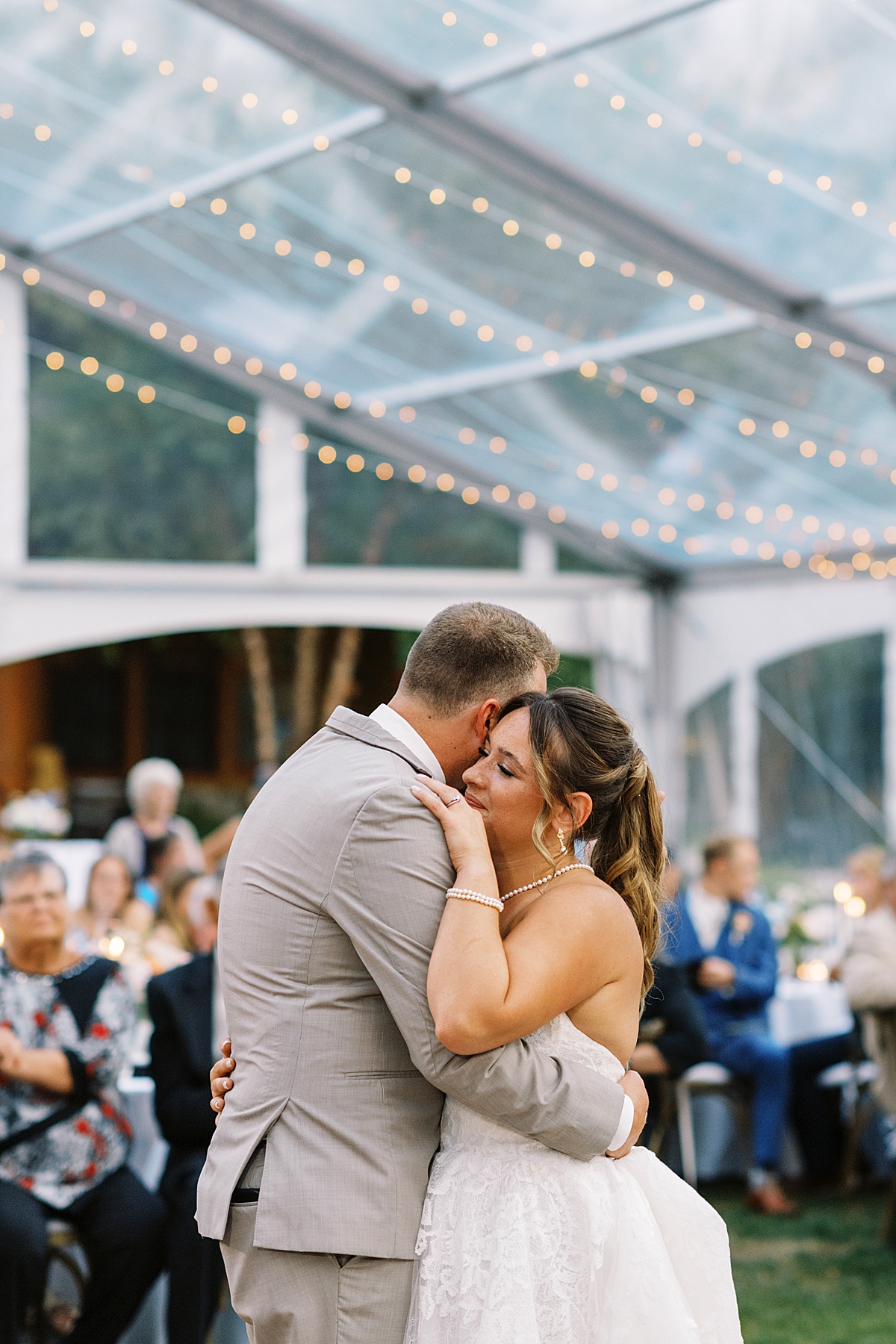 Bride and groom hold each other close while dancing at The Lodge at Spruce Peak