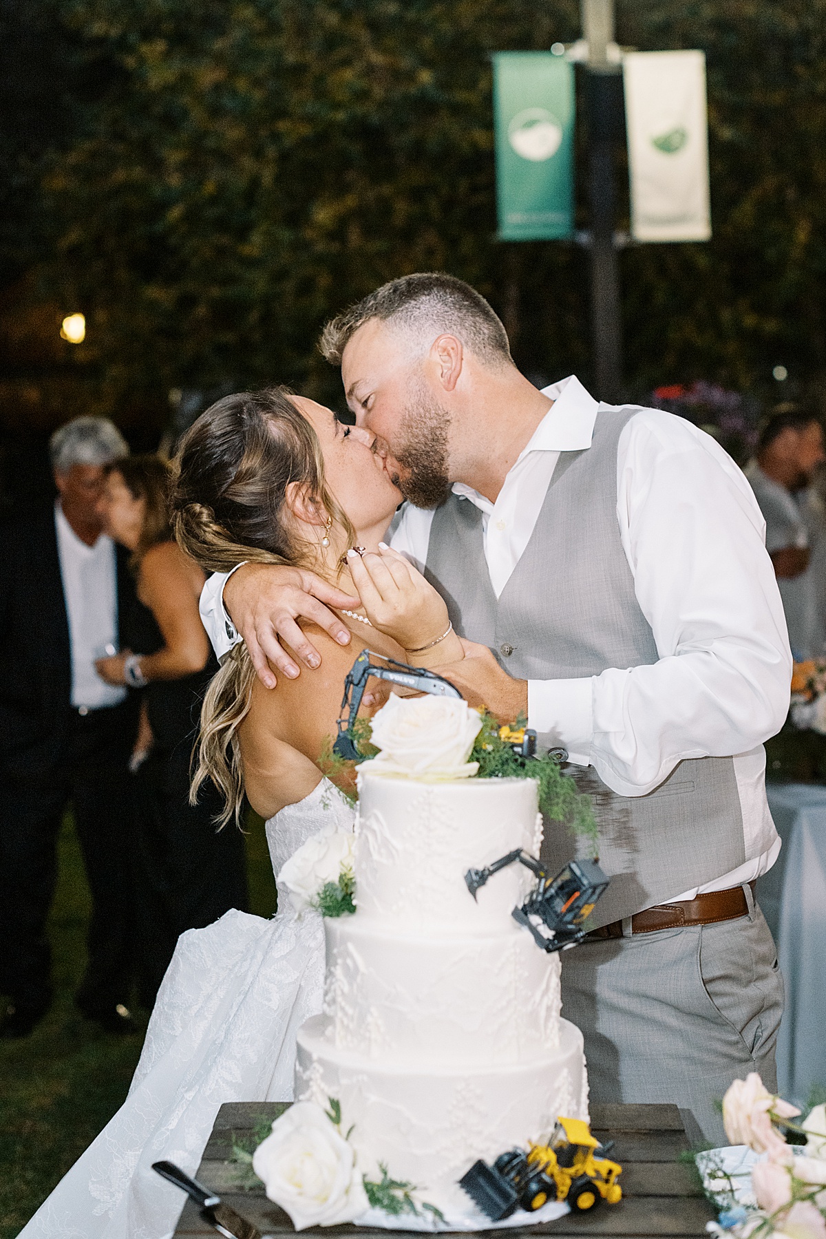 Bride and groom share a kiss and enjoy the cake for Boston Wedding Photographer