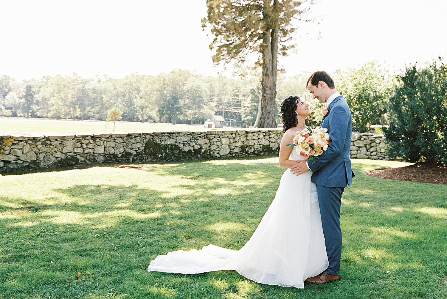 groom looks lovingly at bride on lawn at Mount Hope Farm