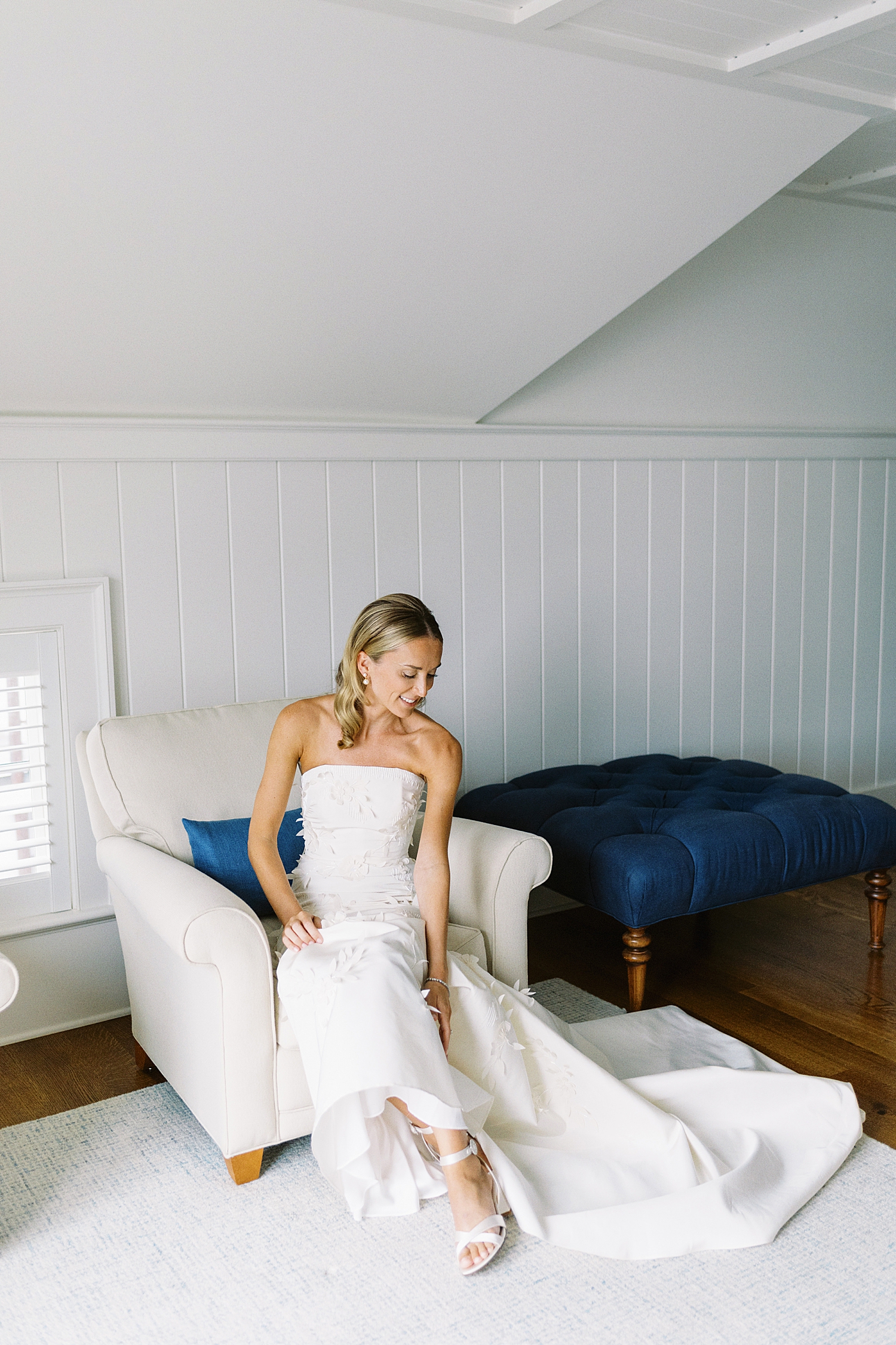 woman in white dress adjusts her shoes at Oyster Harbors Club