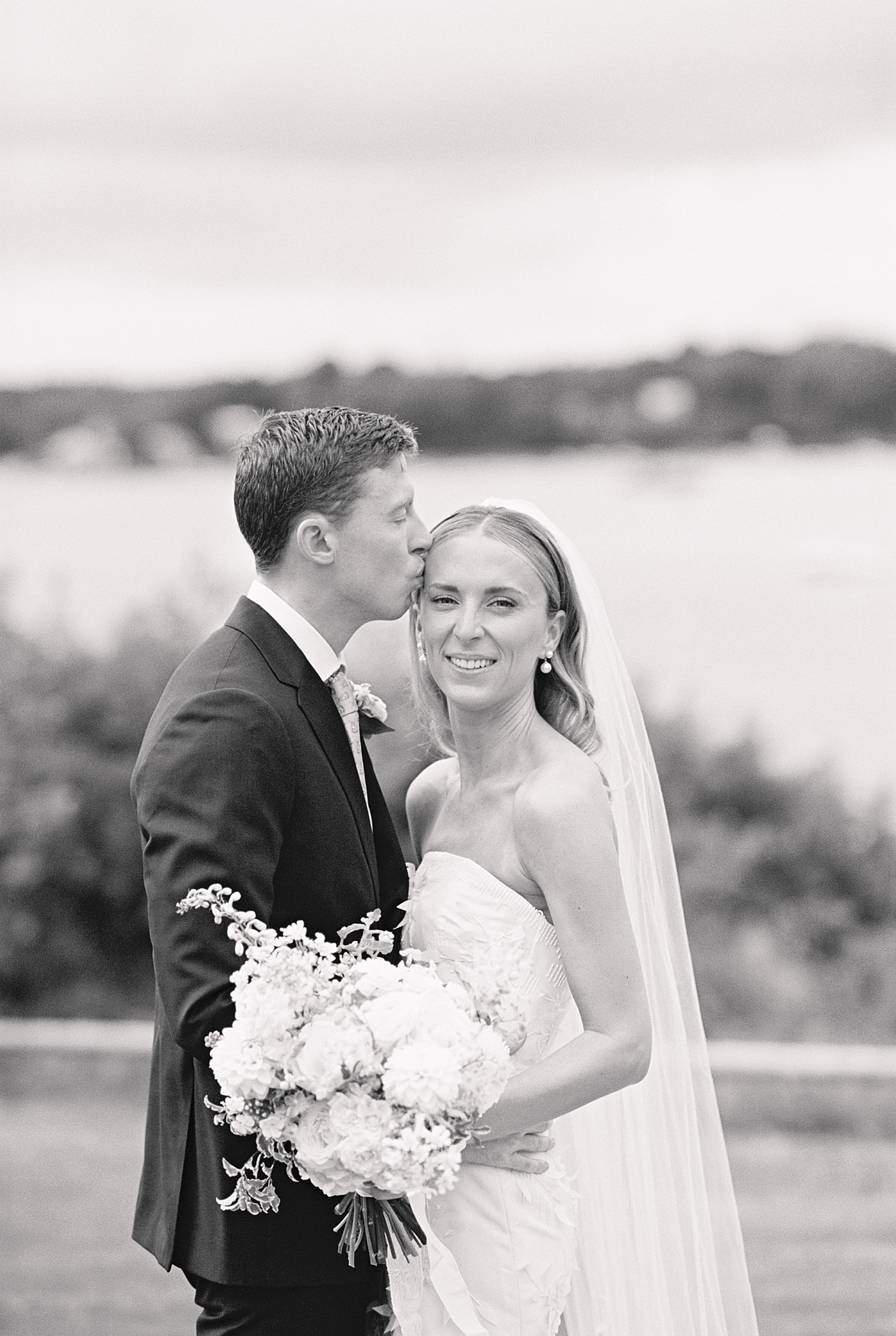 man leans in to kiss fiance's temple by Cape Cod wedding photographer