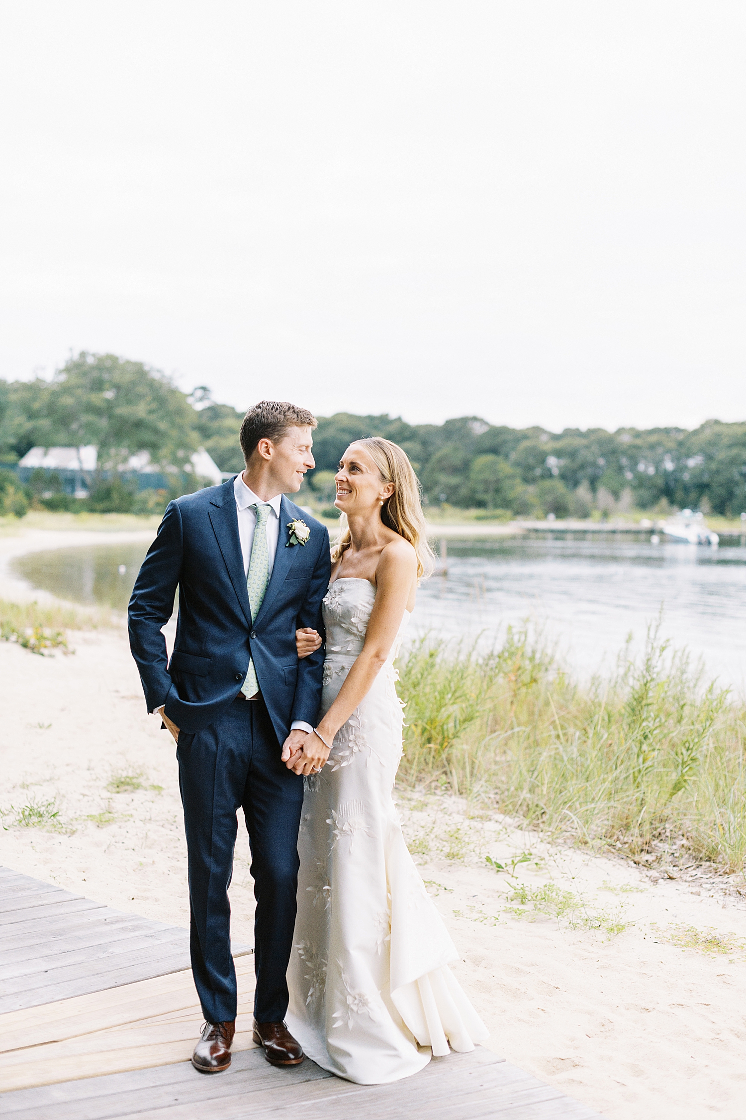 blonde woman looks lovingly at fiance before ceremony by Cape Cod wedding photographer