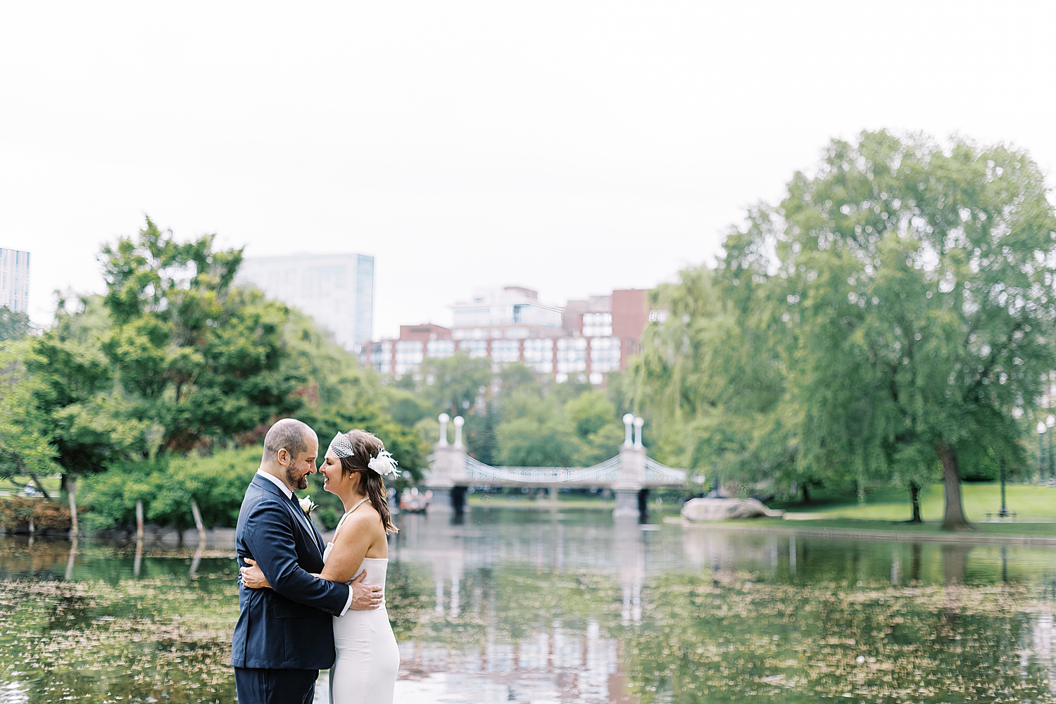 man leans in to hold wife next to pond by Lynne Reznick Photography