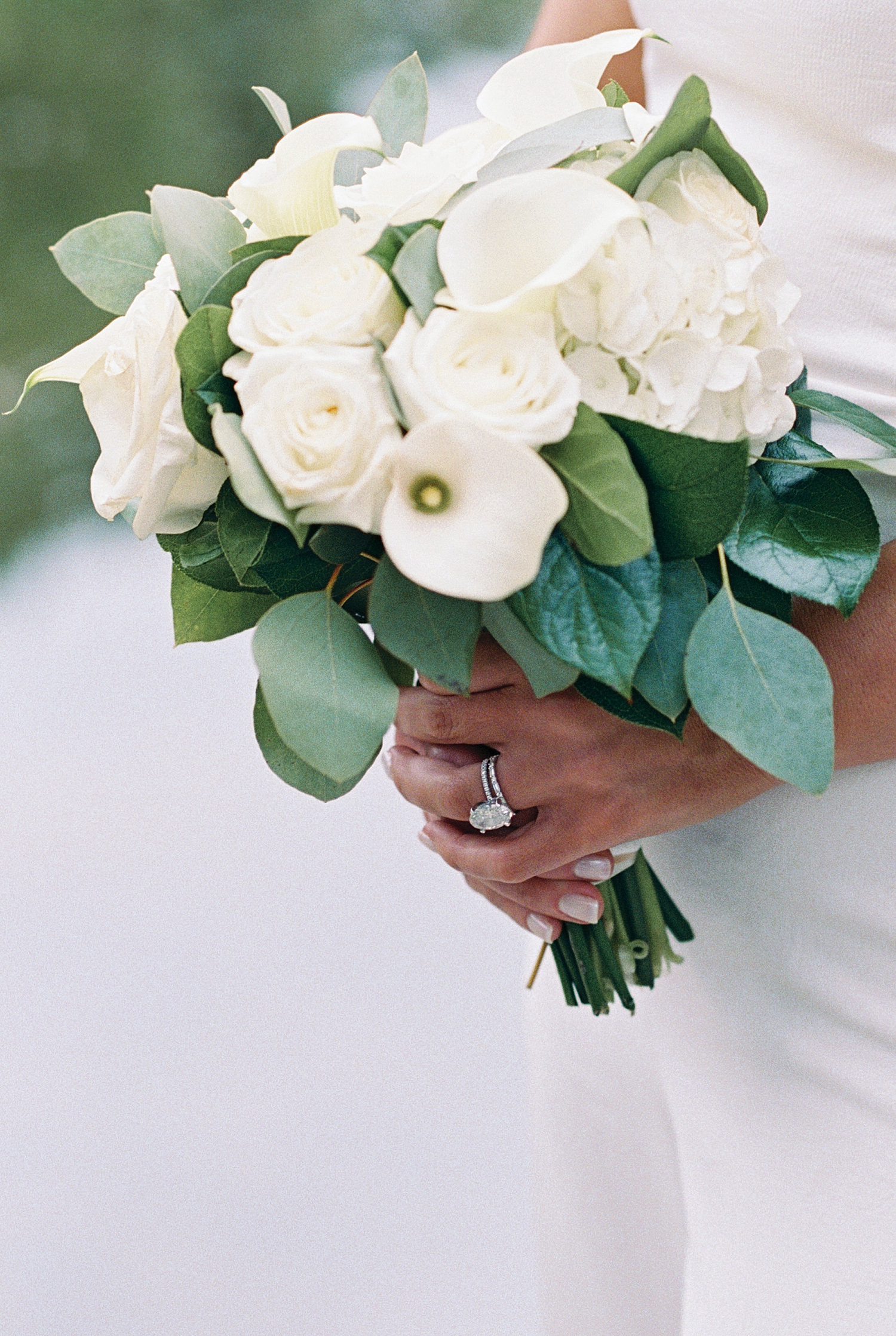 bride holds bouquet of white roses and lillies at Boston Public Garden