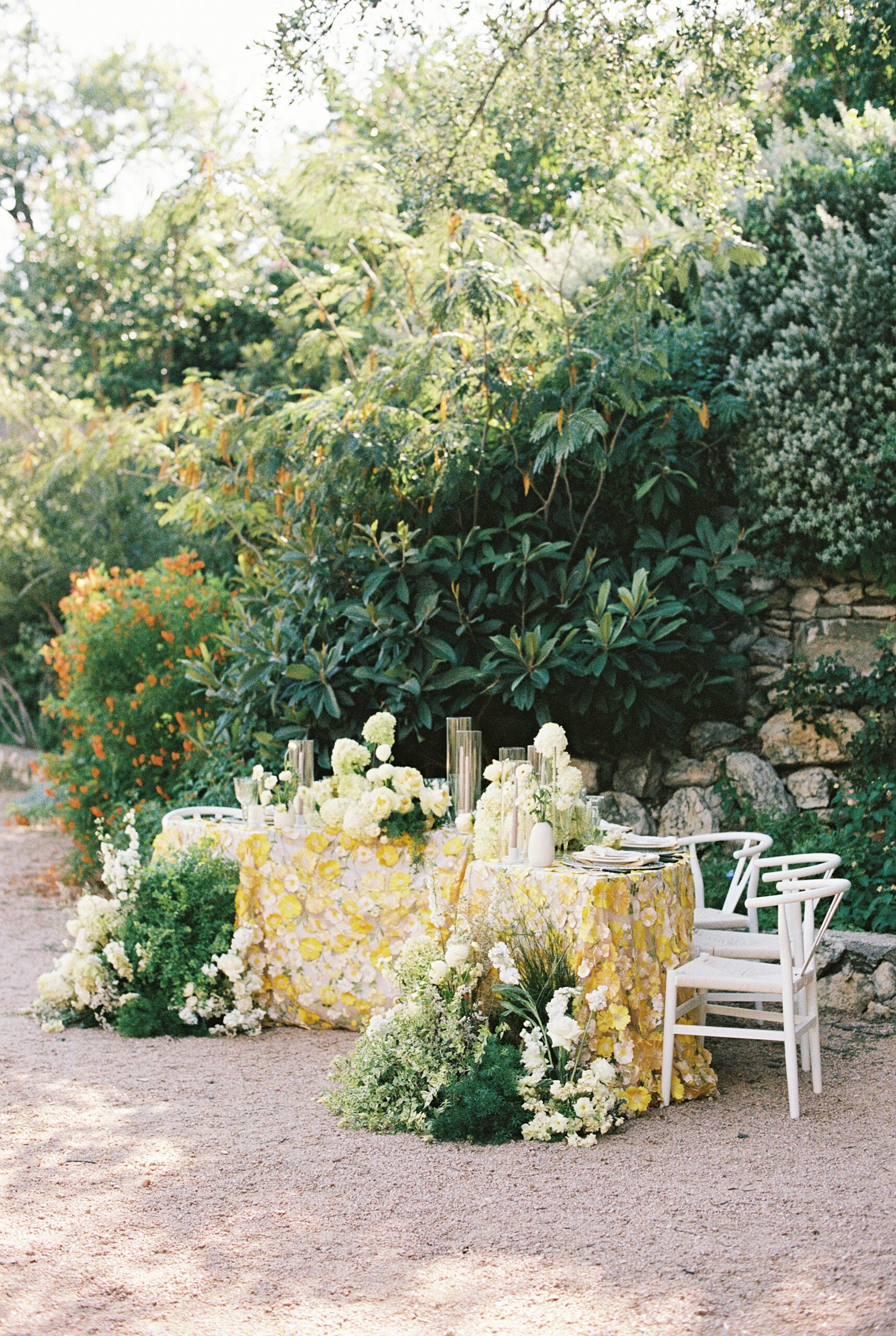 al fresco table set for wedding at Villa Antonia with white flowers and yellow floral linen