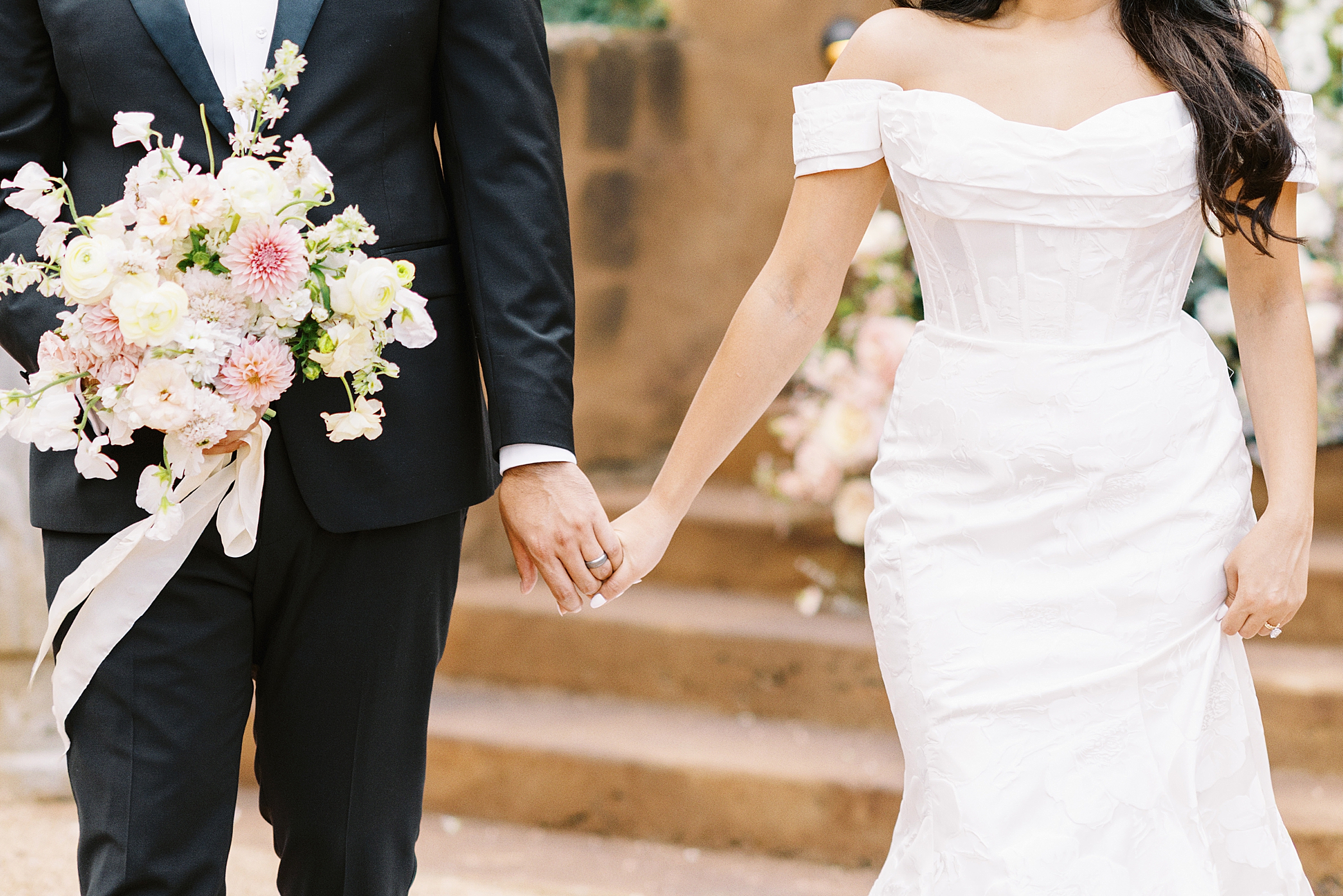 detail of bride and groom holding hands in Texas hill country