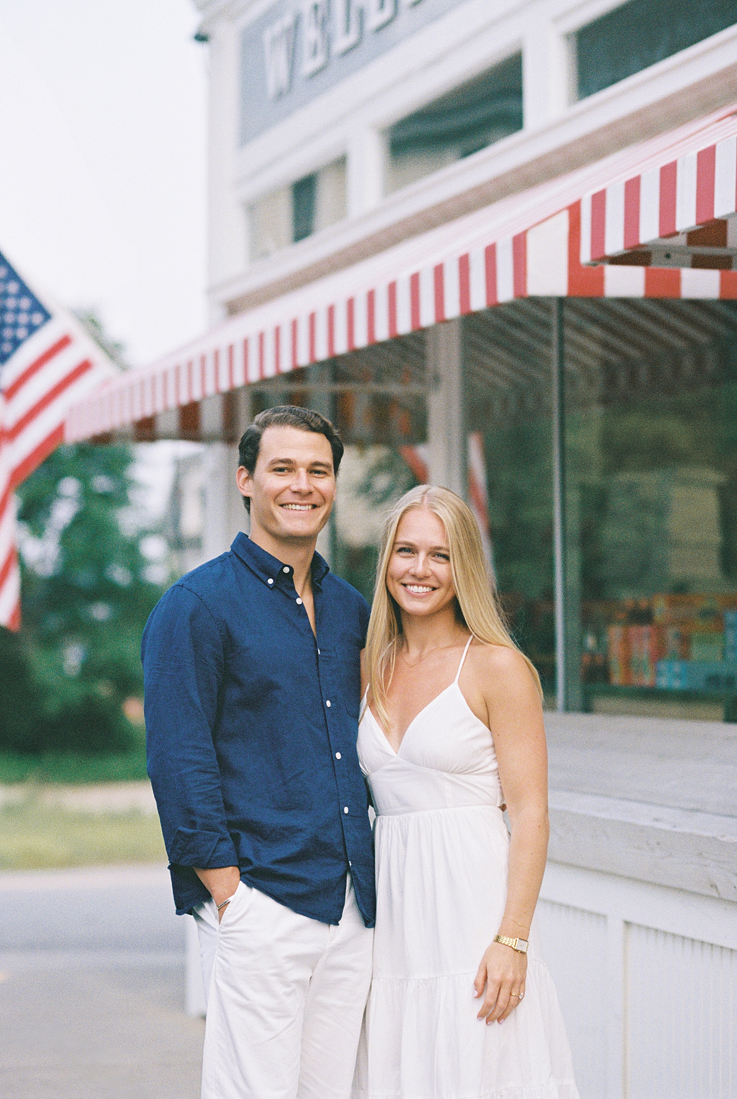 blonde woman in white dress hugs fiancé Engagement Session in Wellfleet