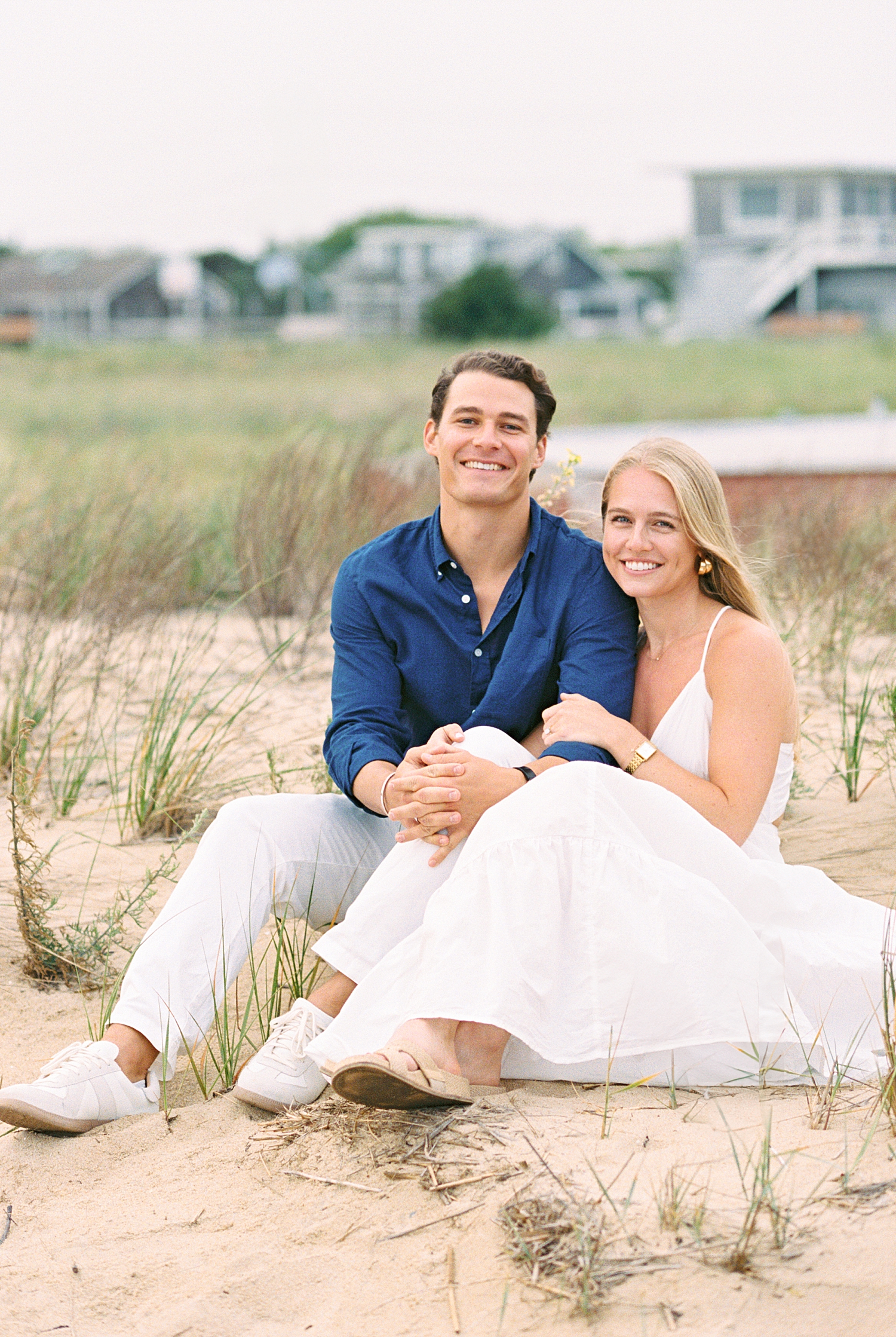 couple sits on sandy shore for Engagement Session in Wellfleet