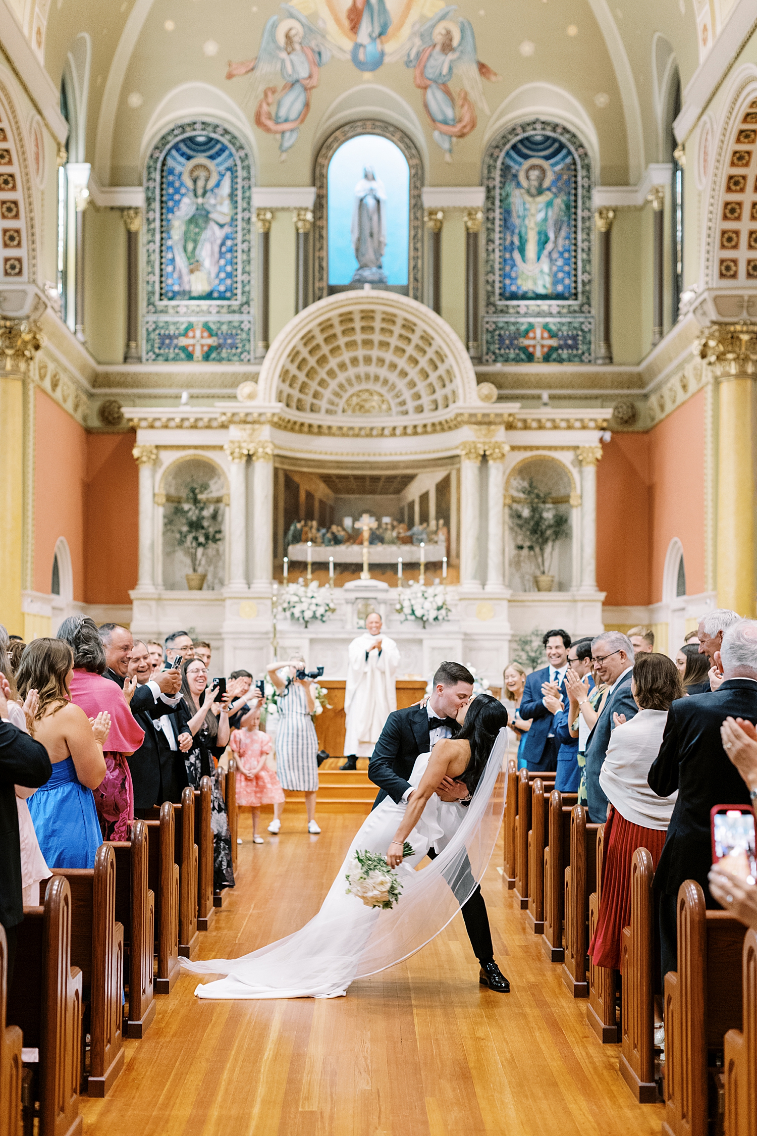 man dips his new wife for a kiss at the end of the alter by New England Wedding Photographer